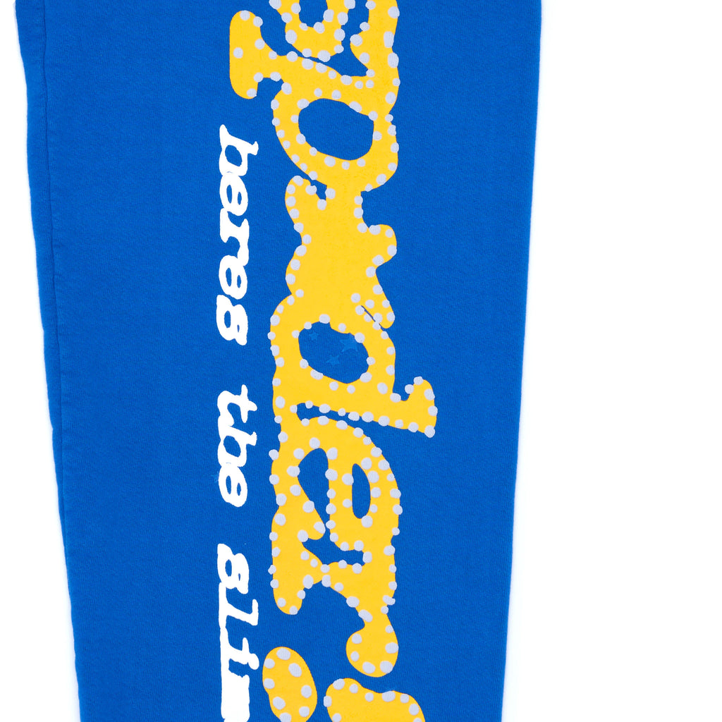TC BLUE sweatpant with yellow puff print "SP5DER!" text and star design down the leg.