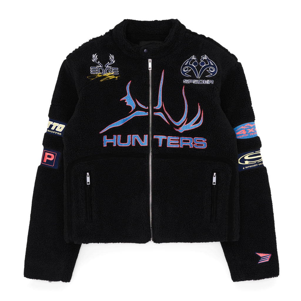 Black sherpa moto jacket with "HUNTERS" graphic, SP5DER patches, zip closure, and welt pockets.