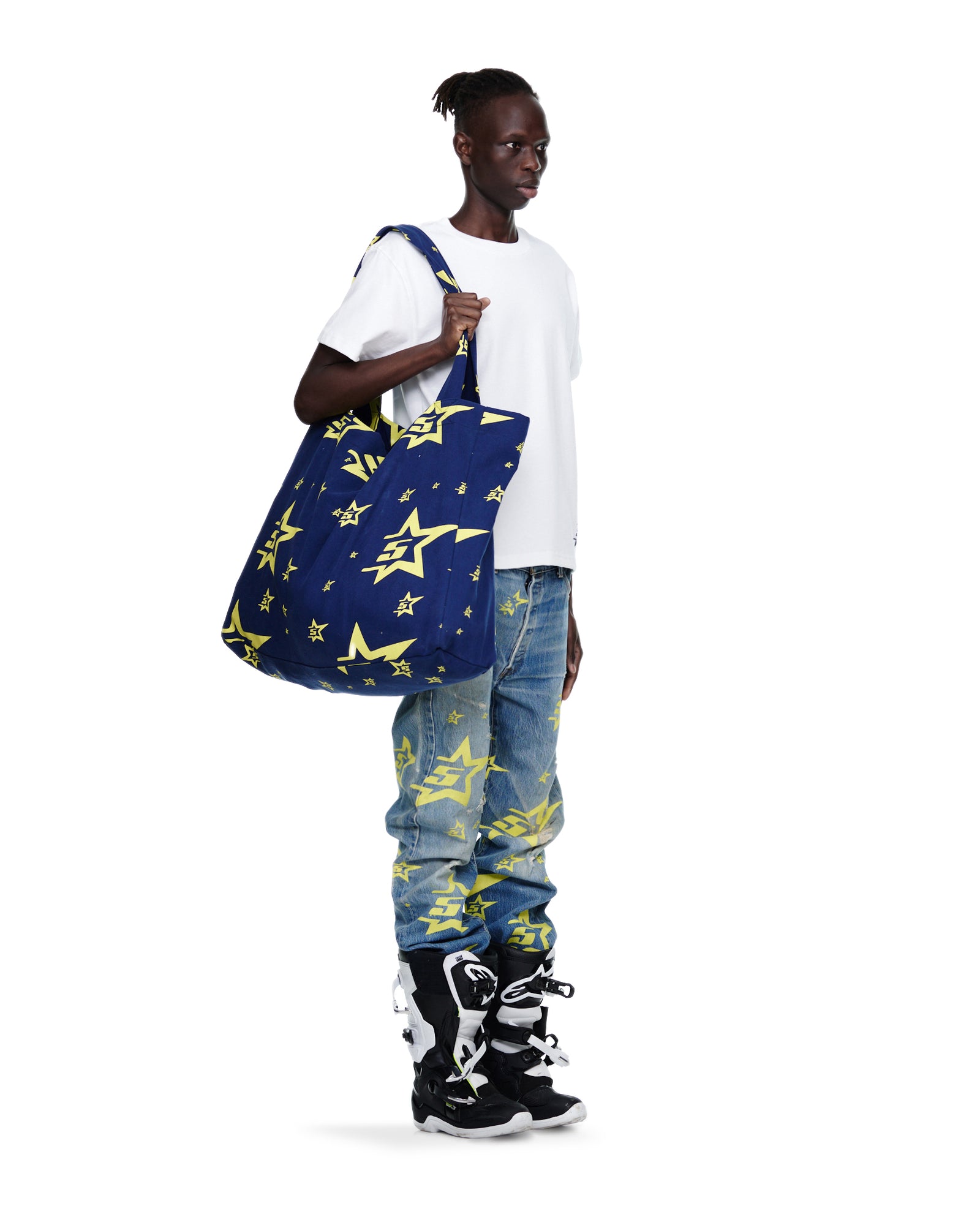 Man holds a large navy 5STAR XL TOTE with yellow star print, made from 8oz brushed twill.