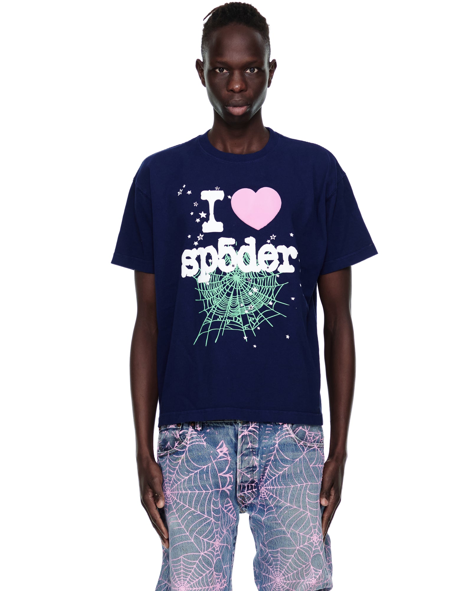 Male model in navy cotton SOUVENIR TEE with "I ❤️ sp5der" graphic, spiderweb, and stars.