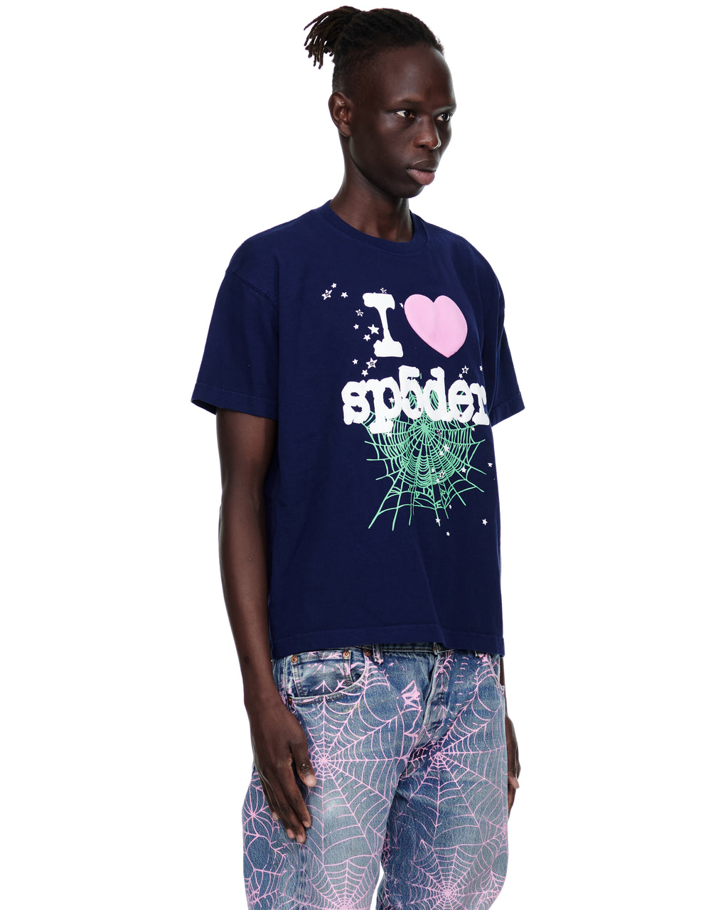 Male model in navy 14oz cotton Souvenir Tee with "I love spider" graphic and pink web-print jeans.