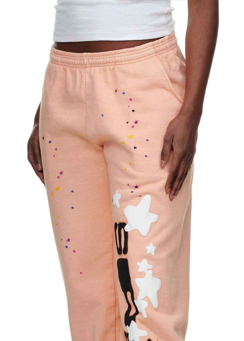 Peach SP5 BELLINI SWEATPANT with colorful small stars and large white puff print stars and black text down the leg.