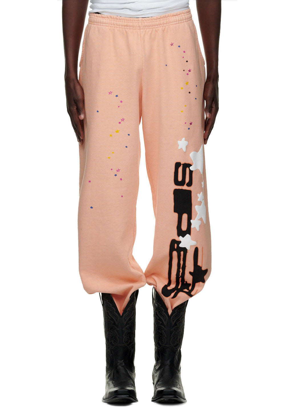 Bellini SP5 sweatpants with puff print stars and "SP5" text down the leg, worn with black cowboy boots.