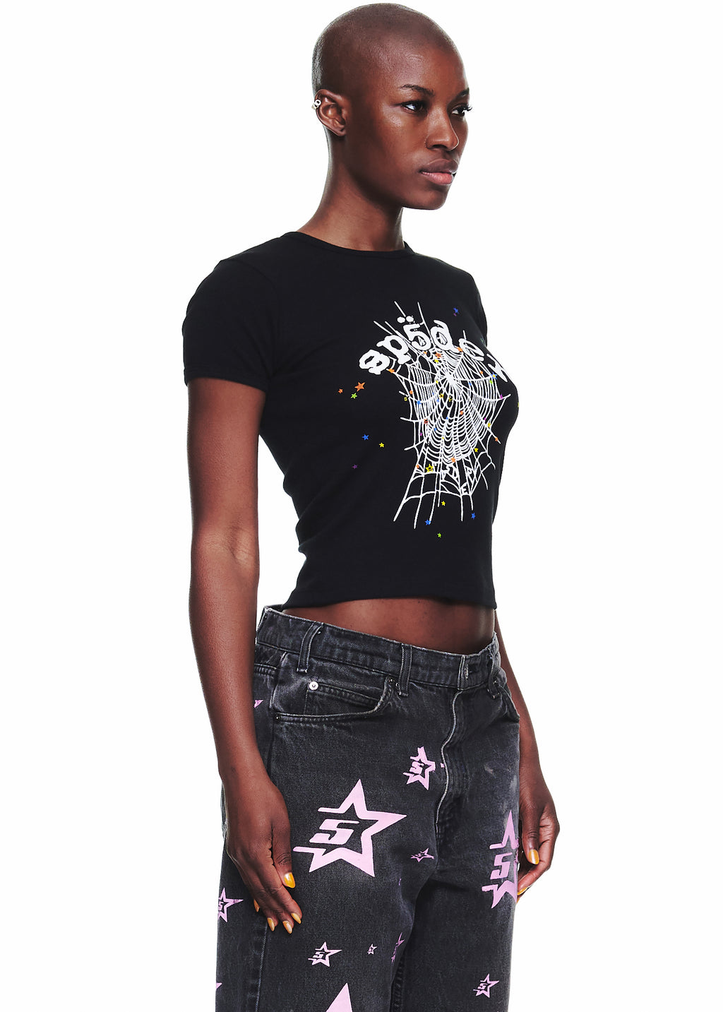 Female model in black OG WEB V2 Baby Tee with white spiderweb graphic, cropped fitted style.