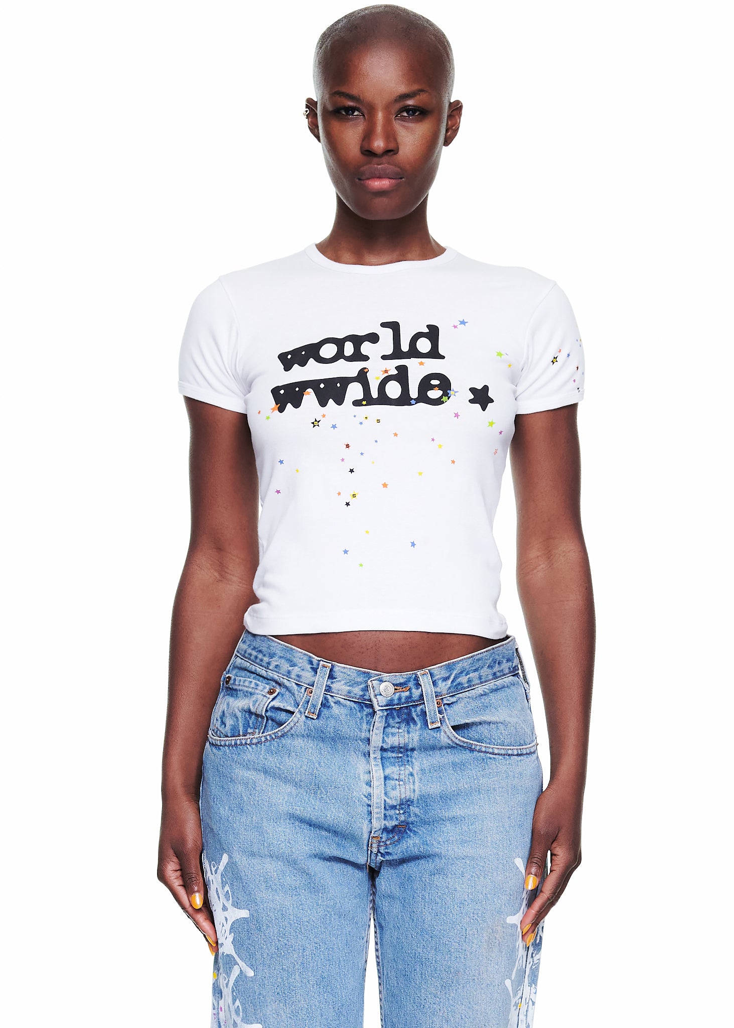 Female model in a white 100% cotton cropped tee with "world wwide" graphic and colorful stars.