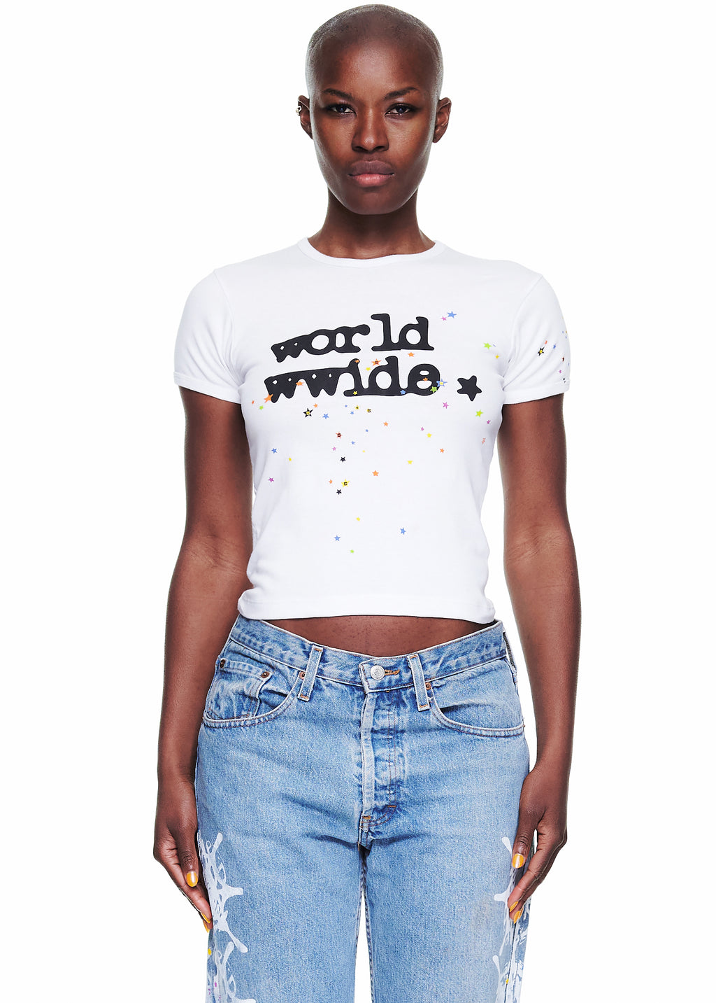 Female model in a white 100% cotton cropped tee with "world wwide" graphic and colorful stars.