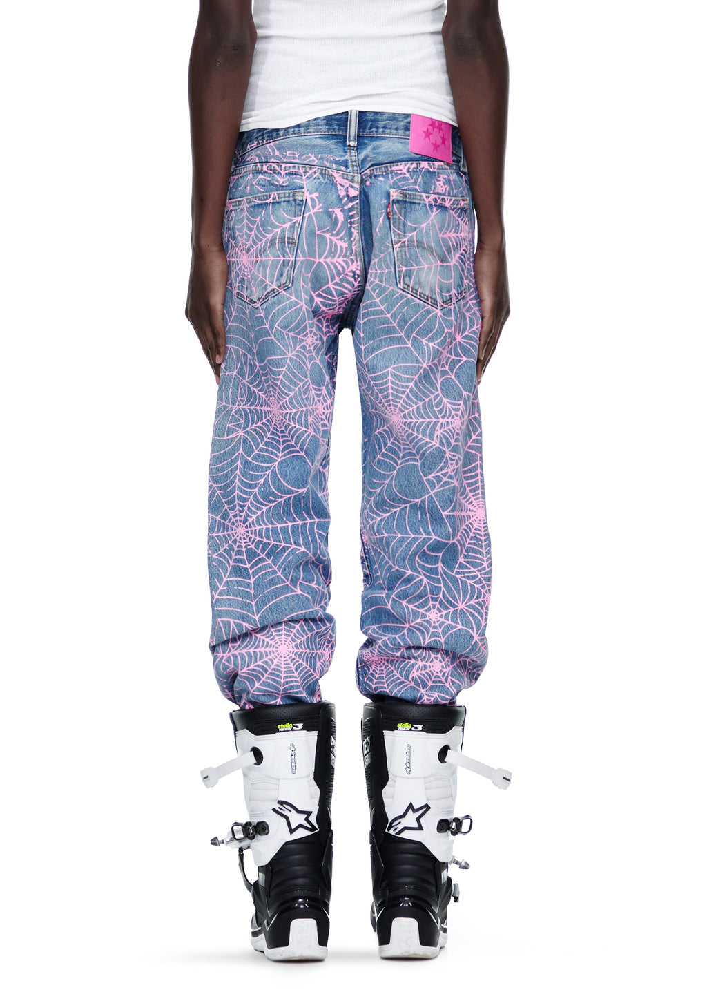 Vintage Levi's 501 denim jeans with all-over pink spiderweb print and a pink SP5DER leather back tab.