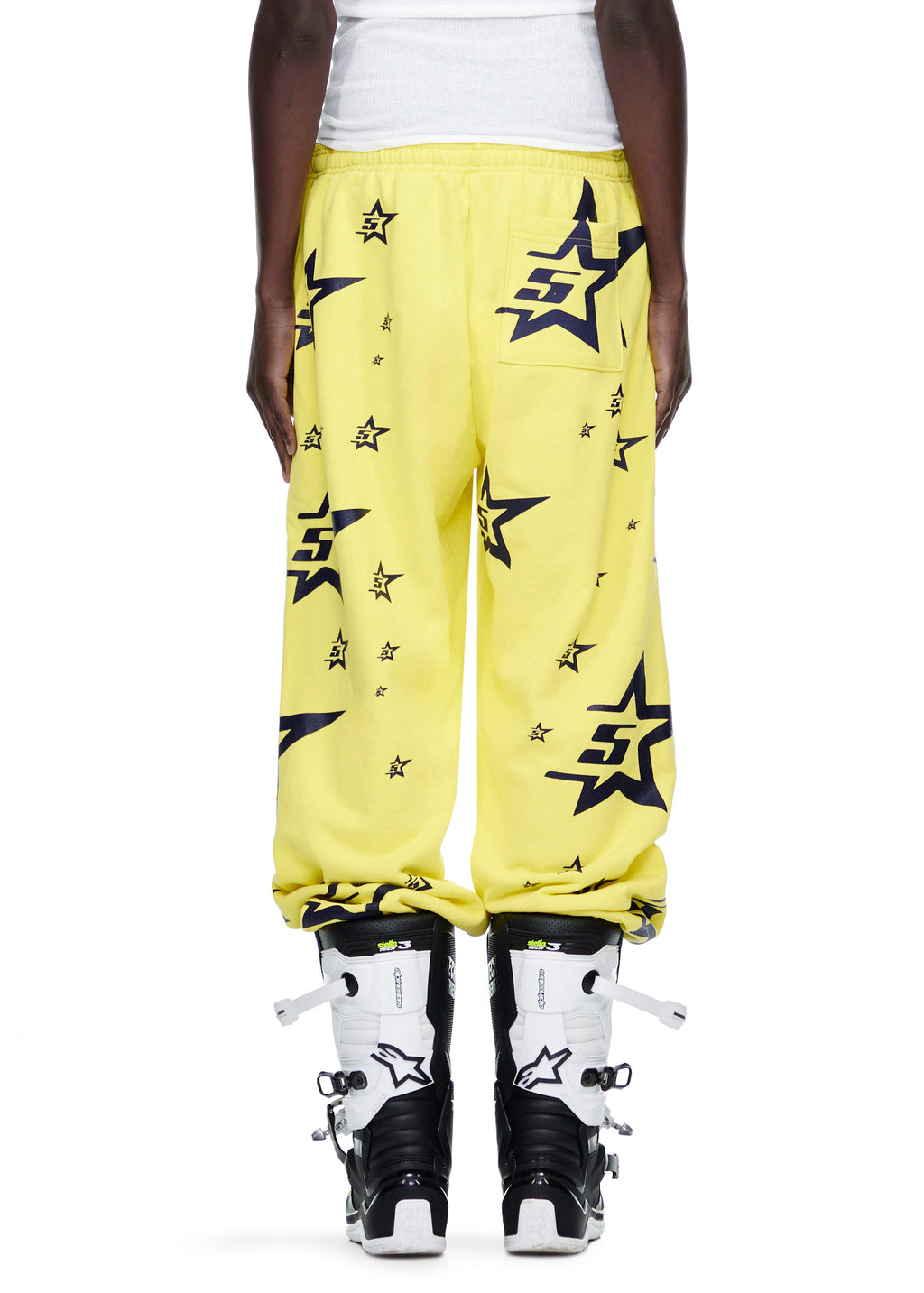 Yellow 5STAR SWEATPANT with all-over black star and "5S" logo print, worn with white motocross boots.