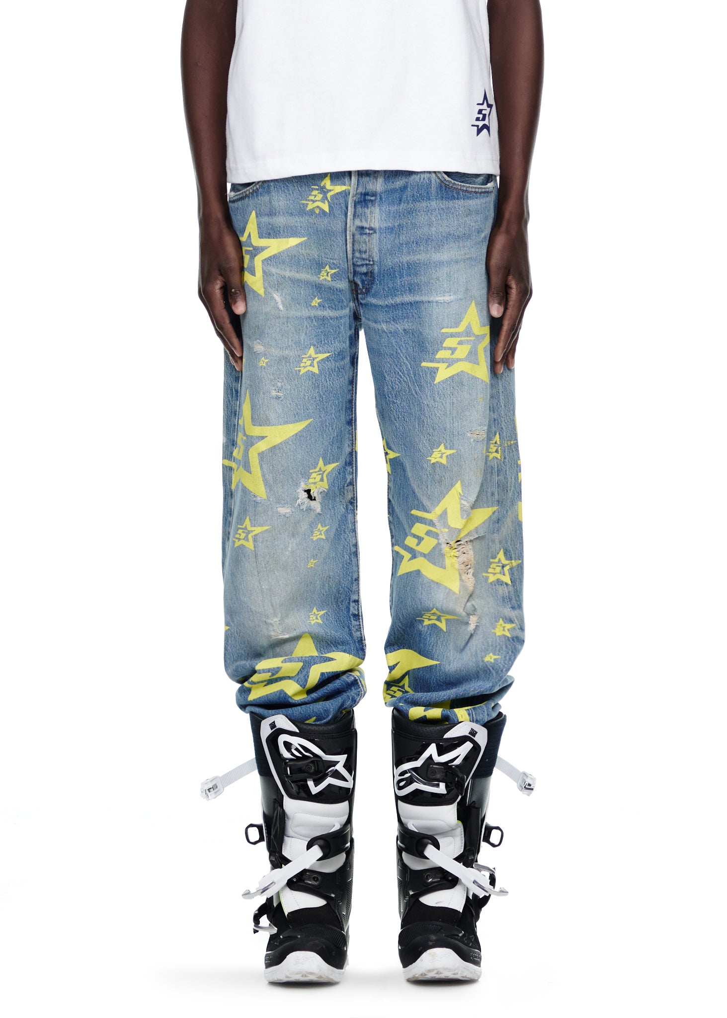 Vintage Levi's 501 denim jeans with yellow 5STAR print and distressing, paired with black and white boots.