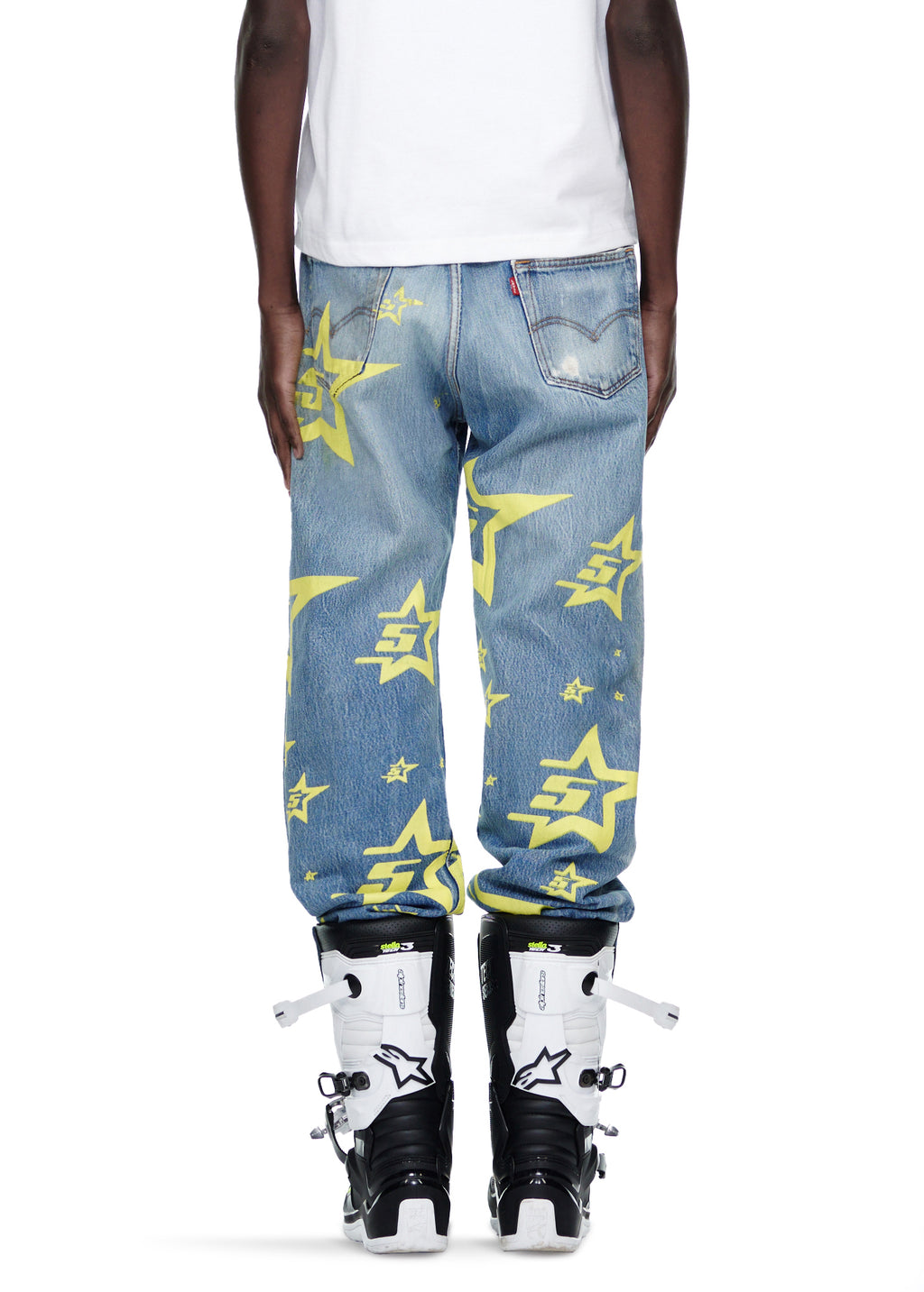 Vintage Levi's 501 denim jeans with yellow 5STAR and star prints, worn by a male model.