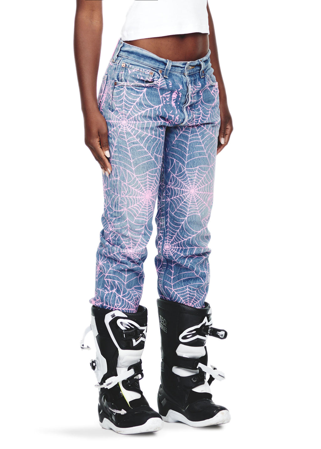 Vintage Levi's 501 denim jeans with all-over pink spider web print, worn by a female model.