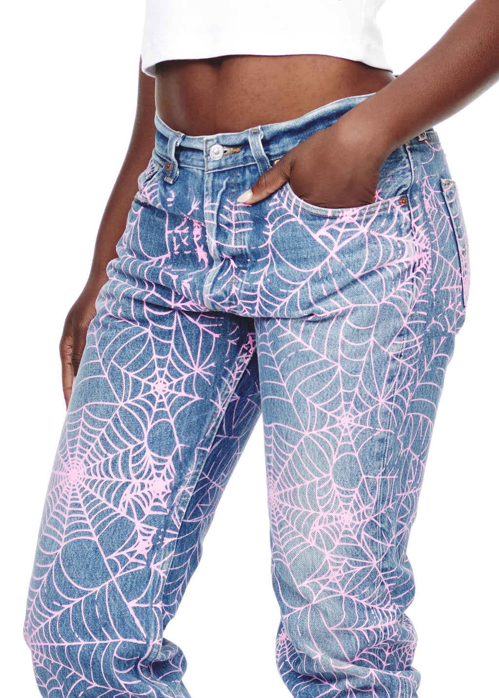 Vintage Levi's 501 denim jeans with all-over pink spider web print, worn by a model.