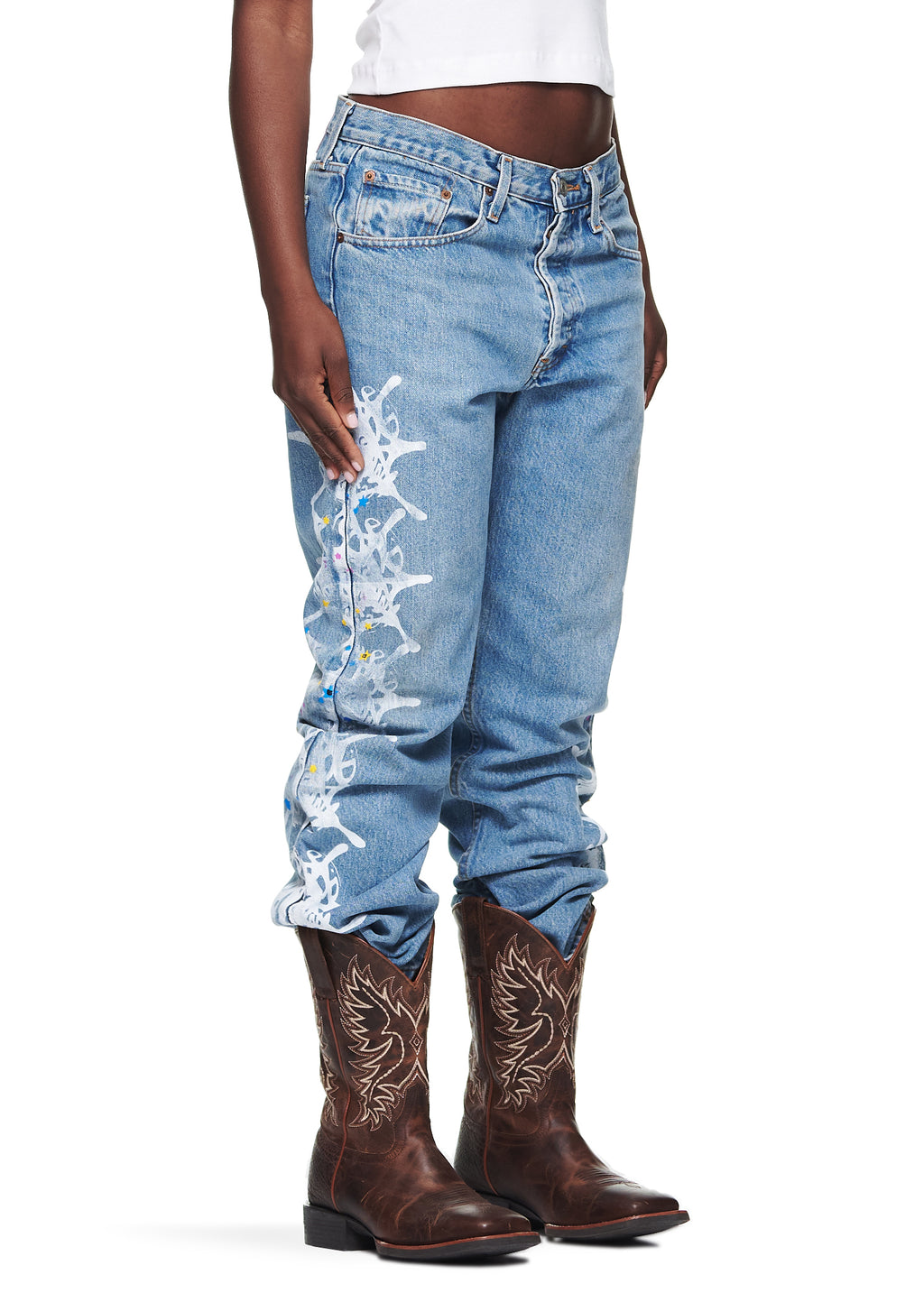 Light wash Vintage Levi's 501 denim jeans with a white contrast web design down the leg, worn with brown cowboy boots.