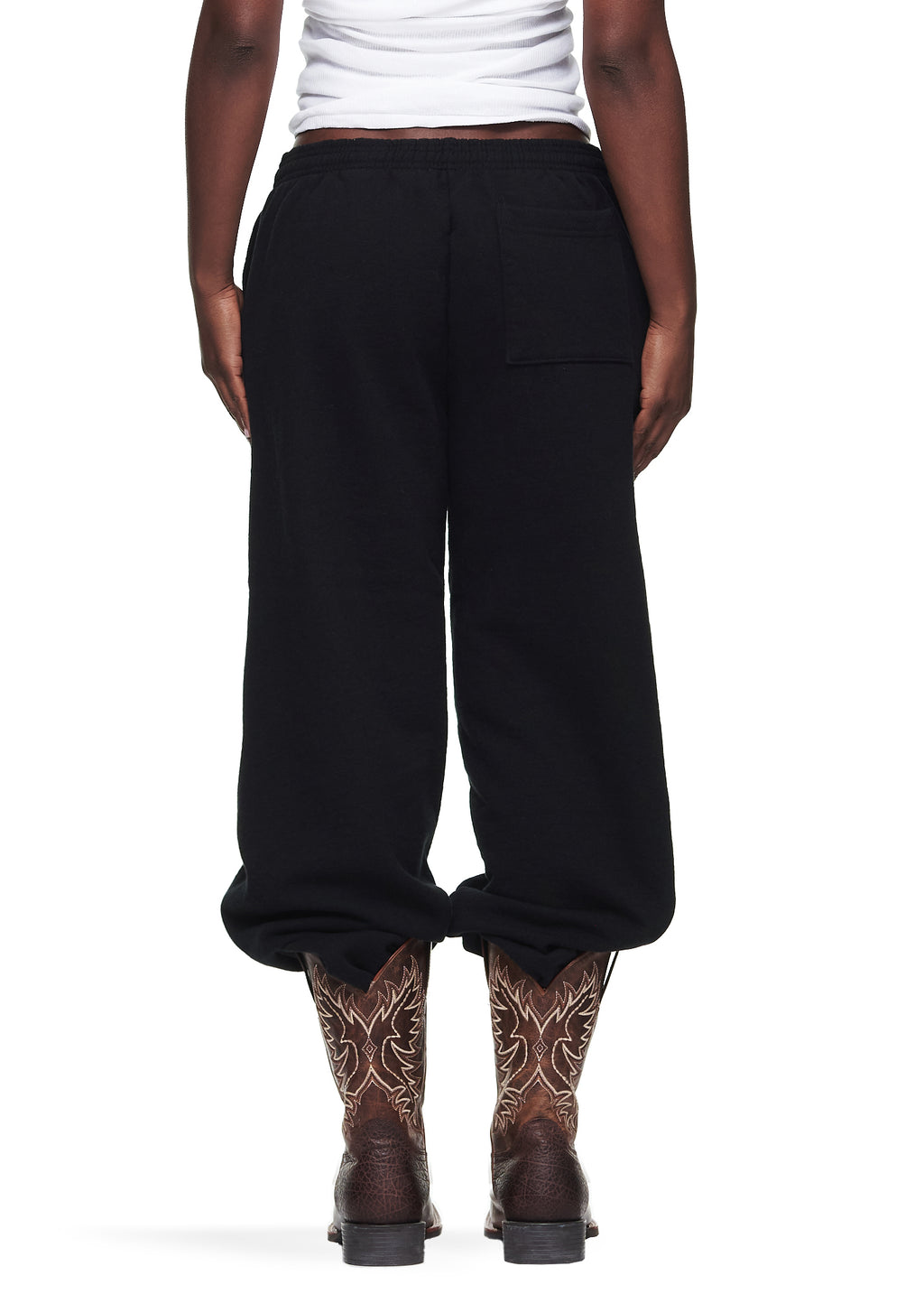 Black OG Web Sweatpants, 23oz fleece, with scattered OG SP5DER text and star print, worn with cowboy boots.