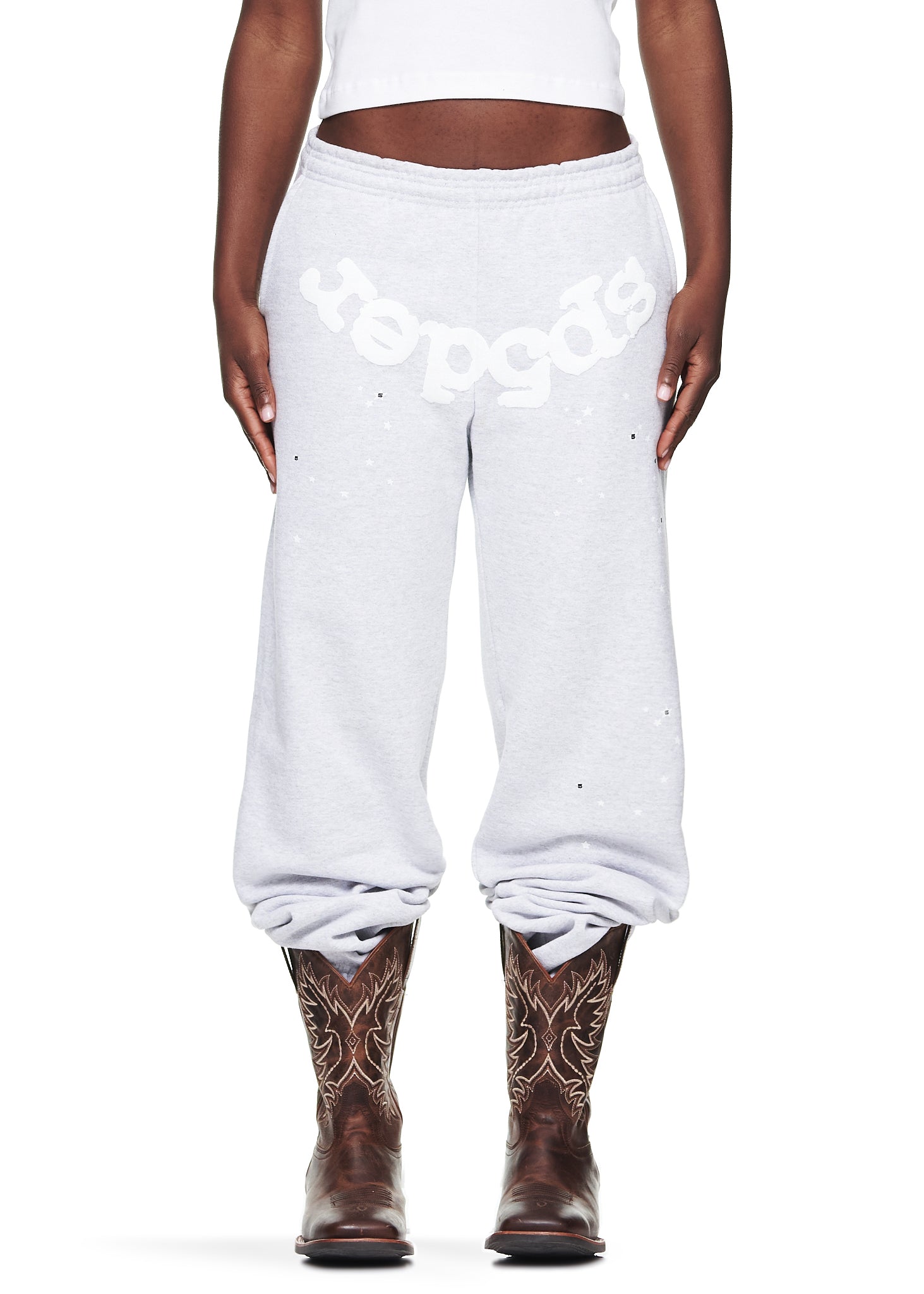 Heather Grey OG Web Sweatpants with white puff print "Sp5der" text, scattered stars, and brown cowboy boots.