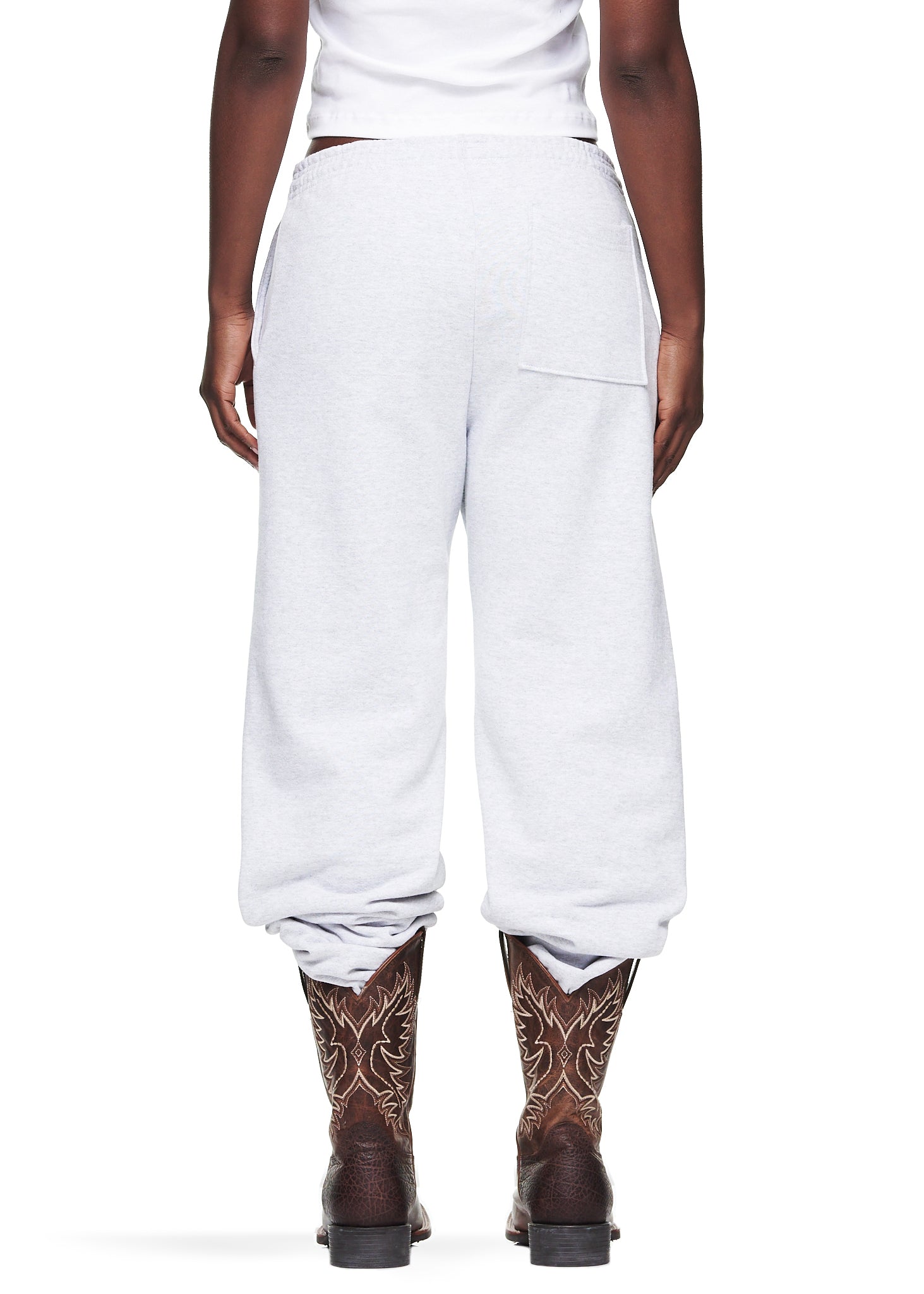 Heather Grey OG Web Sweatpant, 23oz fleece, with scattered OG SP5DER text and star print, worn with cowboy boots.