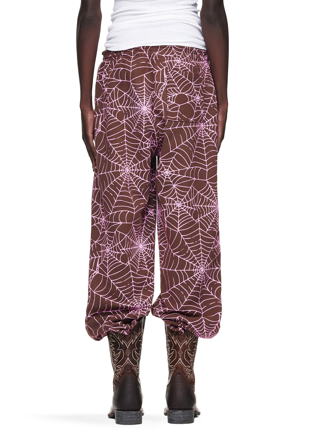 Brown fleece sweatpants with all-over pink cracked web print, worn by a male model.