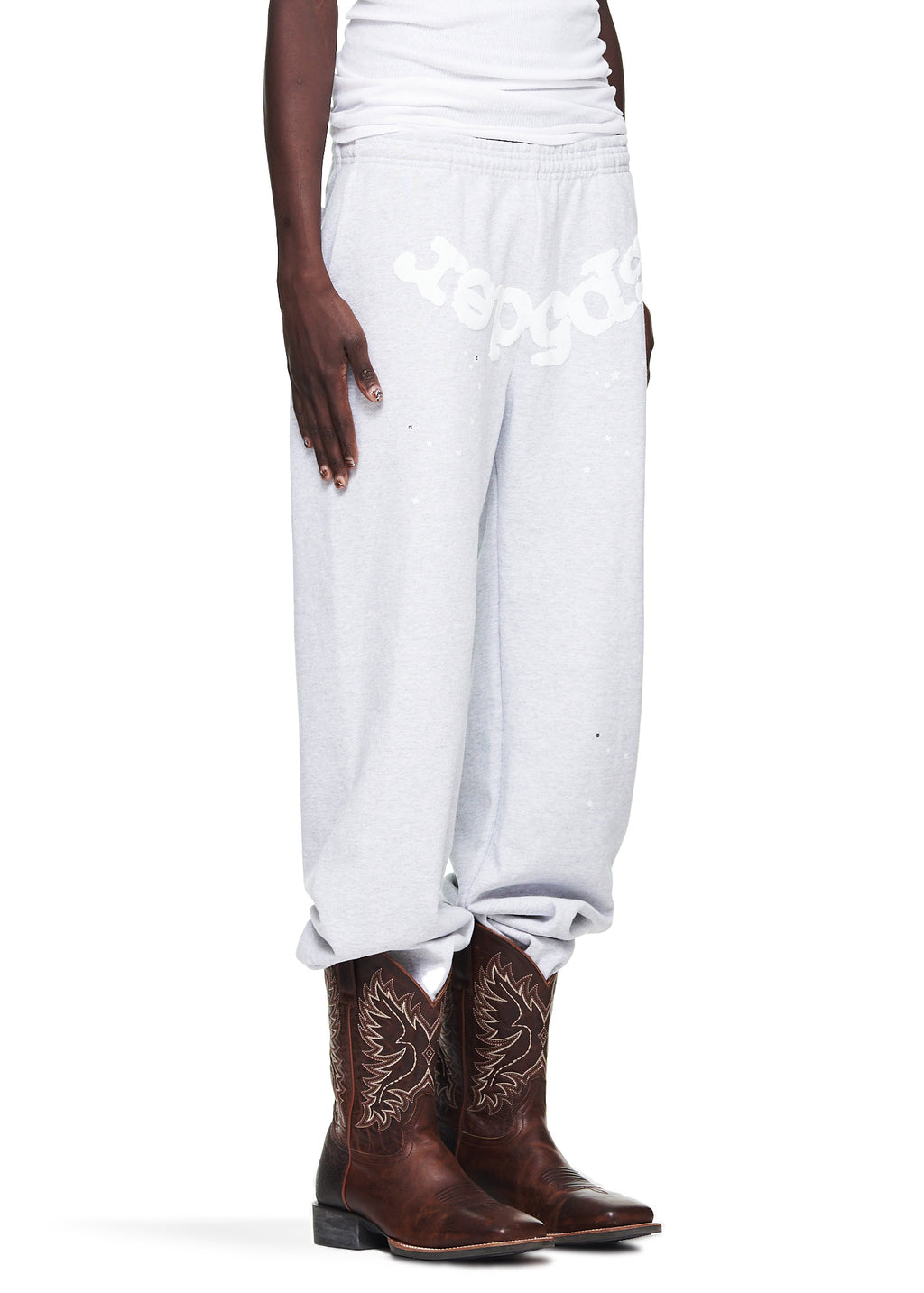 Heather Grey OG Web Sweatpant with white puff print "Sp5der" text and scattered stars, worn with brown cowboy boots.
