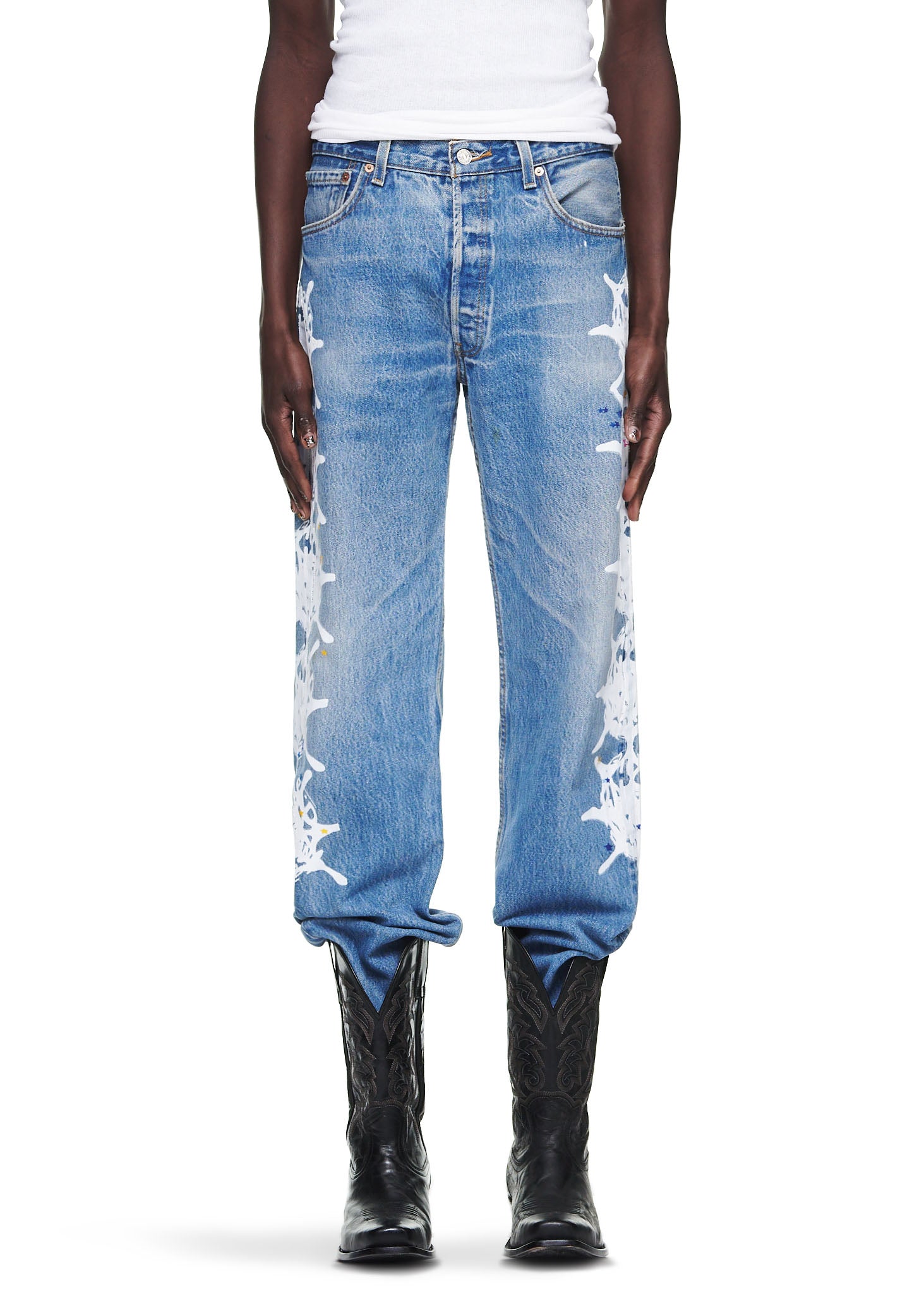Vintage Levi's 501 denim jeans with white contrast web down the leg, worn with black cowboy boots.