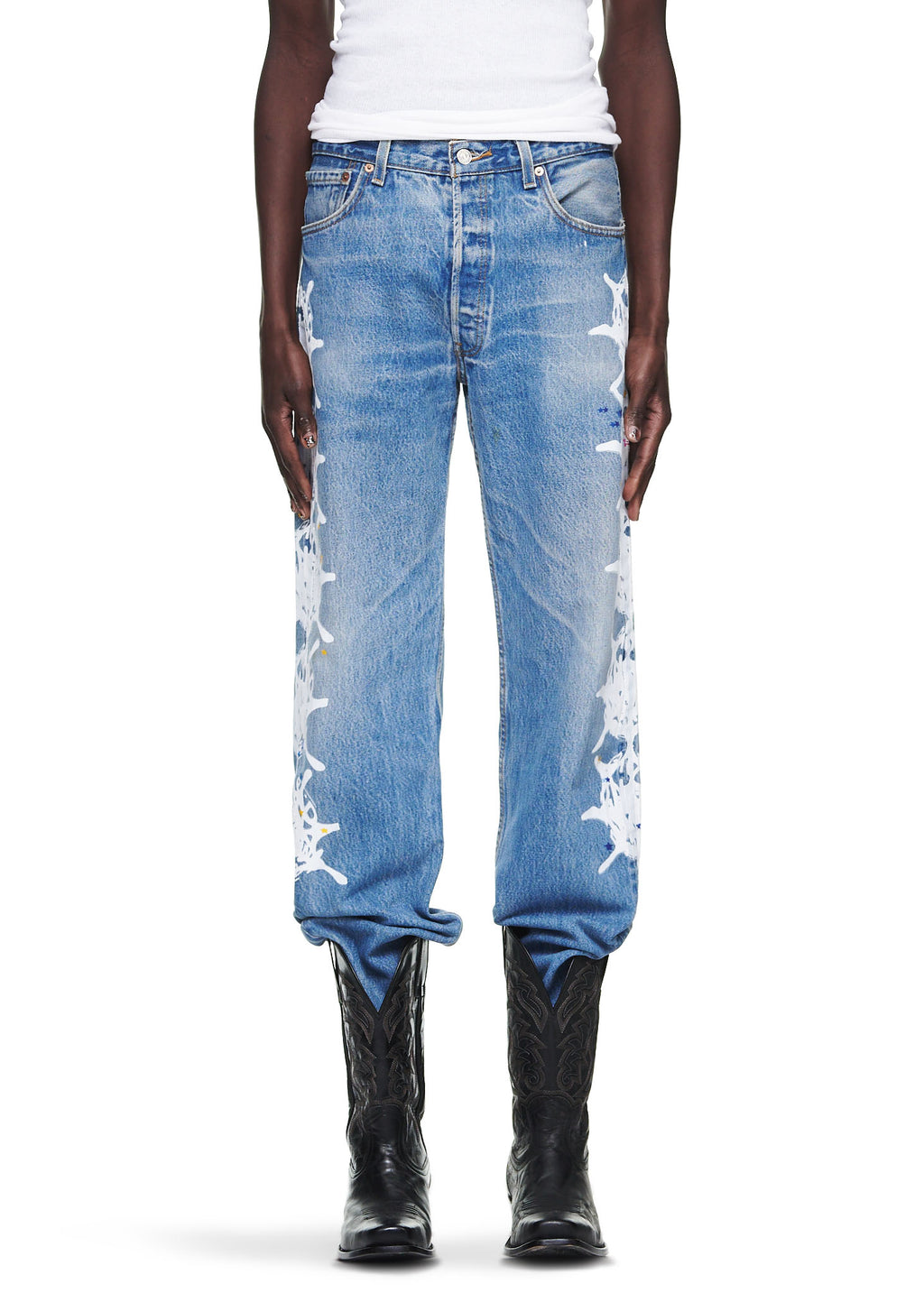 Vintage Levi's 501 denim jeans with white contrast web down the leg, worn with black cowboy boots.