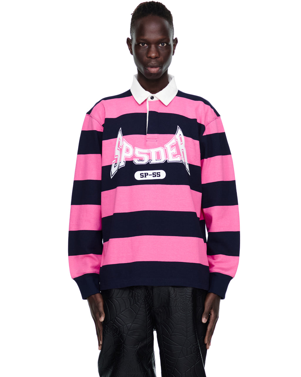 Male model in pink and navy striped rugby shirt with "SP5DER" text on chest.