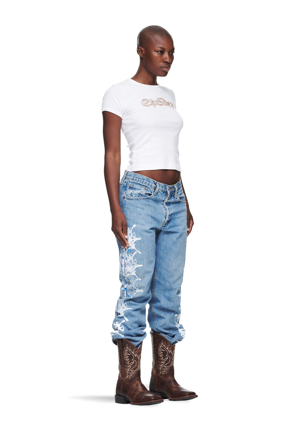 Female model in vintage Levi's 501 denim with white contrast web design, brown cowboy boots, and a white t-shirt.
