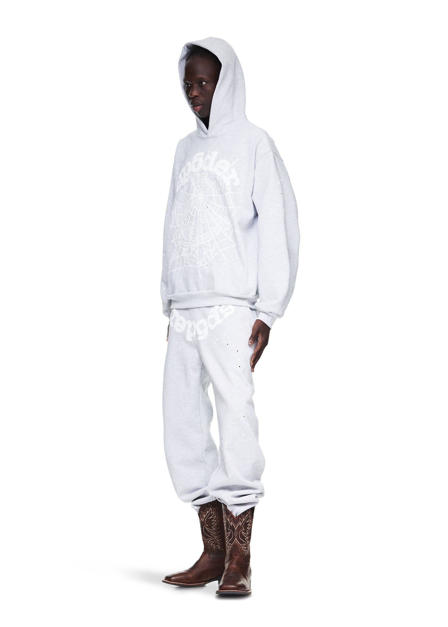Male model in heather grey OG Web Hoodie and sweatpants with brown cowboy boots.