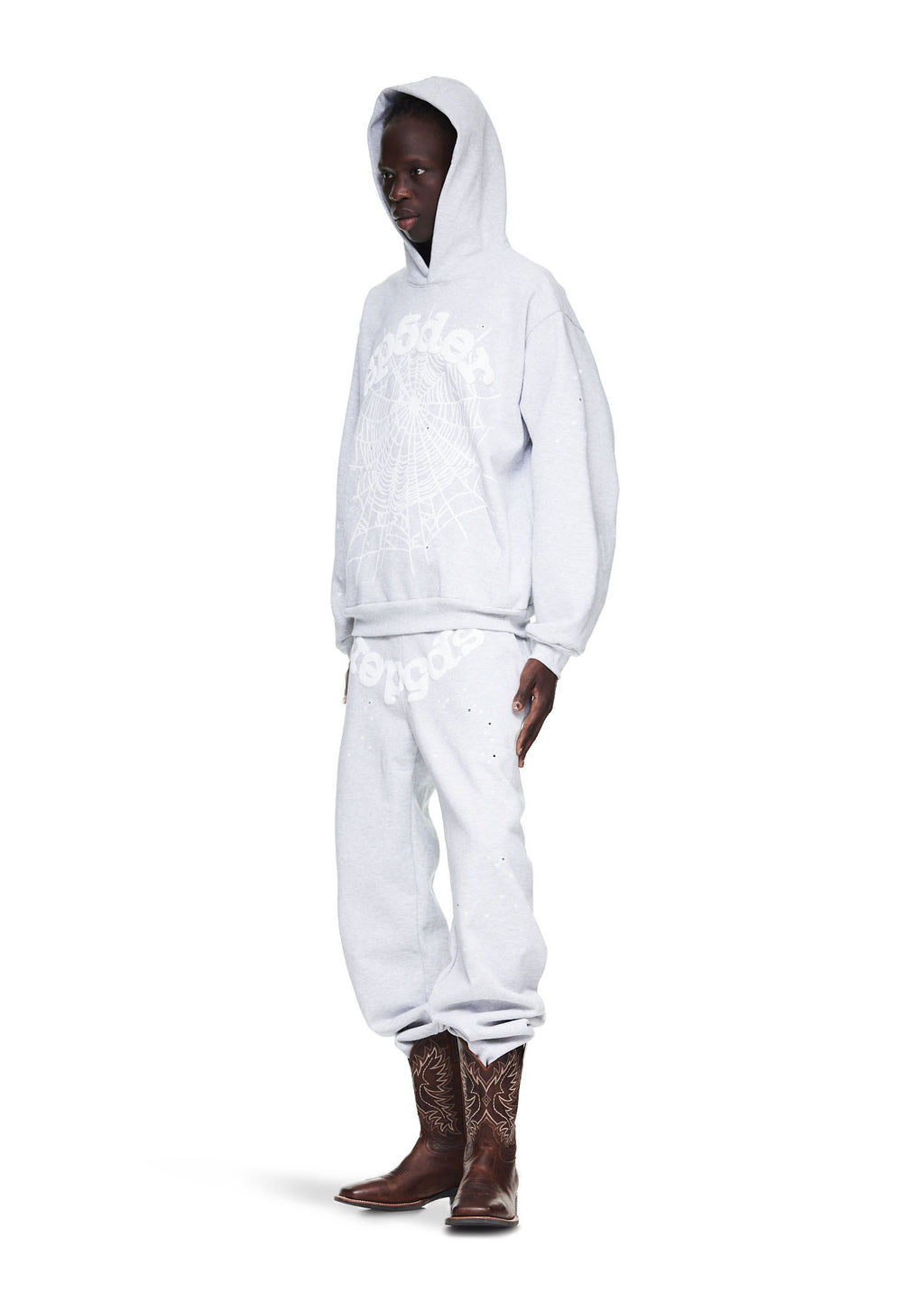 Male model in heather grey OG Web Hoodie and sweatpants with brown cowboy boots.