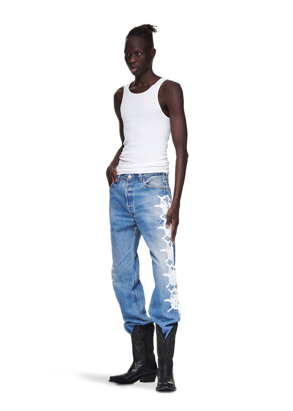 Male model in vintage Levi's 501 denim with white contrast web design, leather SP5DER tab, and black cowboy boots.