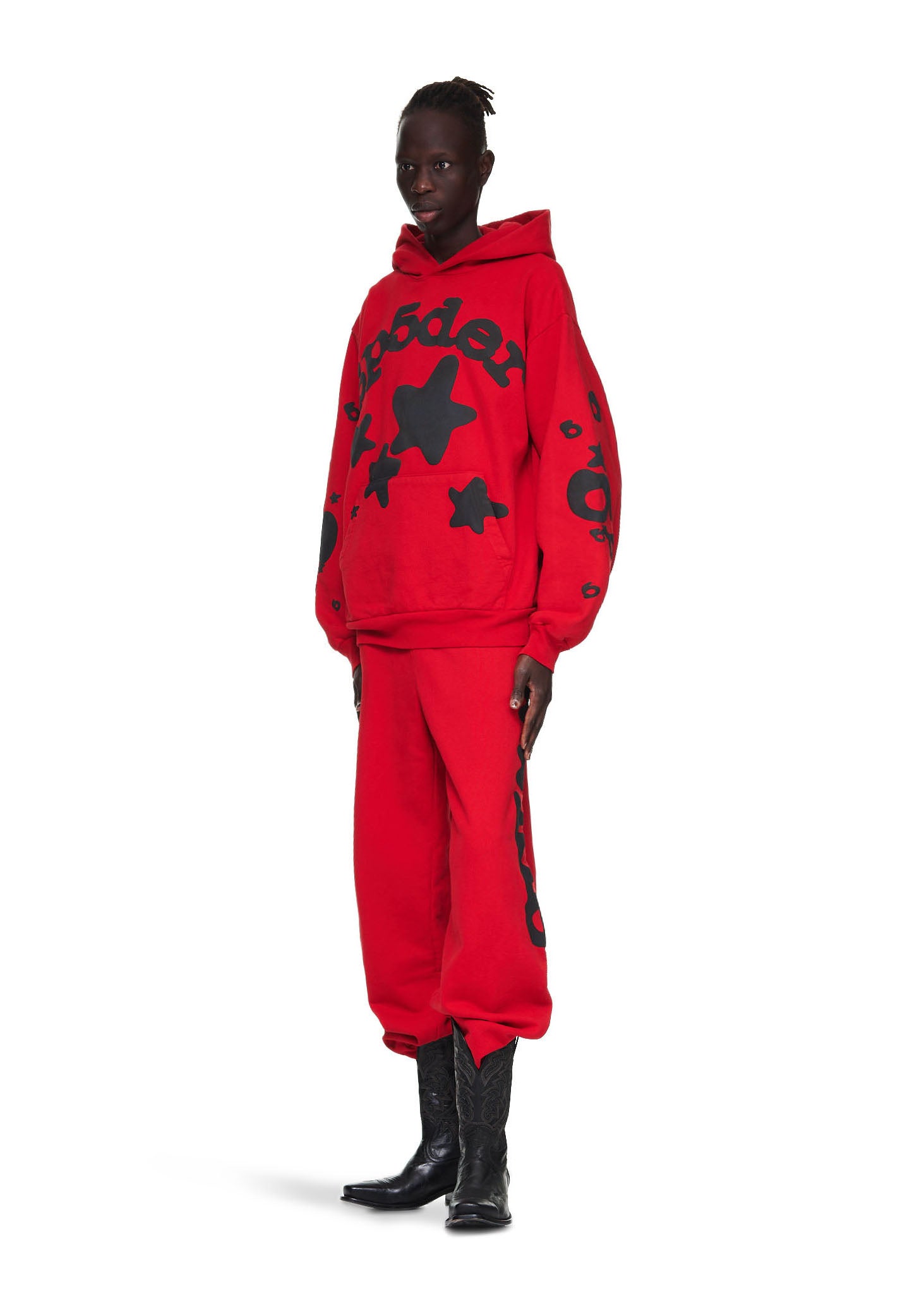 Male model in red Beluga hoodie and sweatpants with black 'SP5DER' and star puff print.