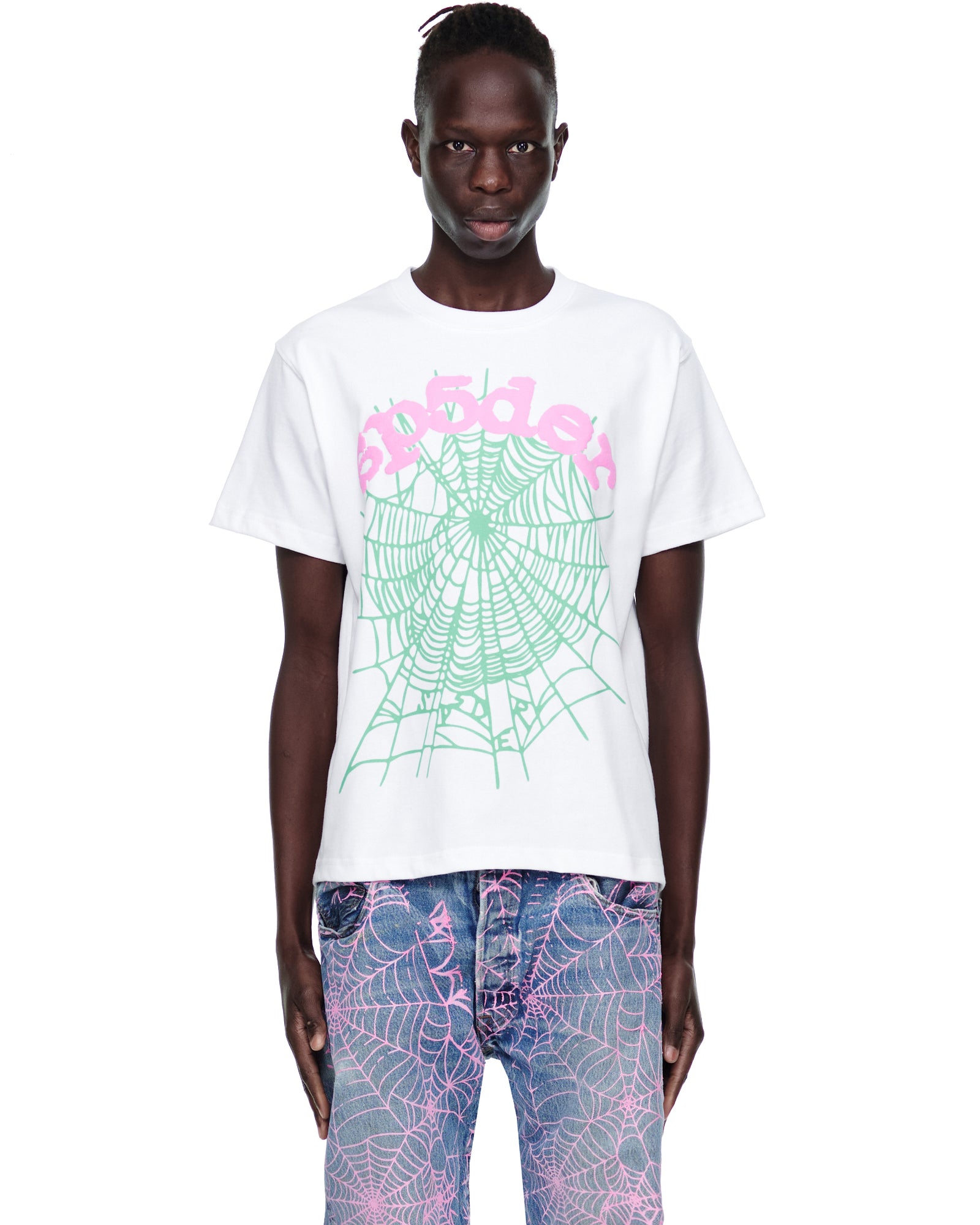 Male model in white 100% cotton OG WEB CANDY TEE with pink text and green spiderweb print.