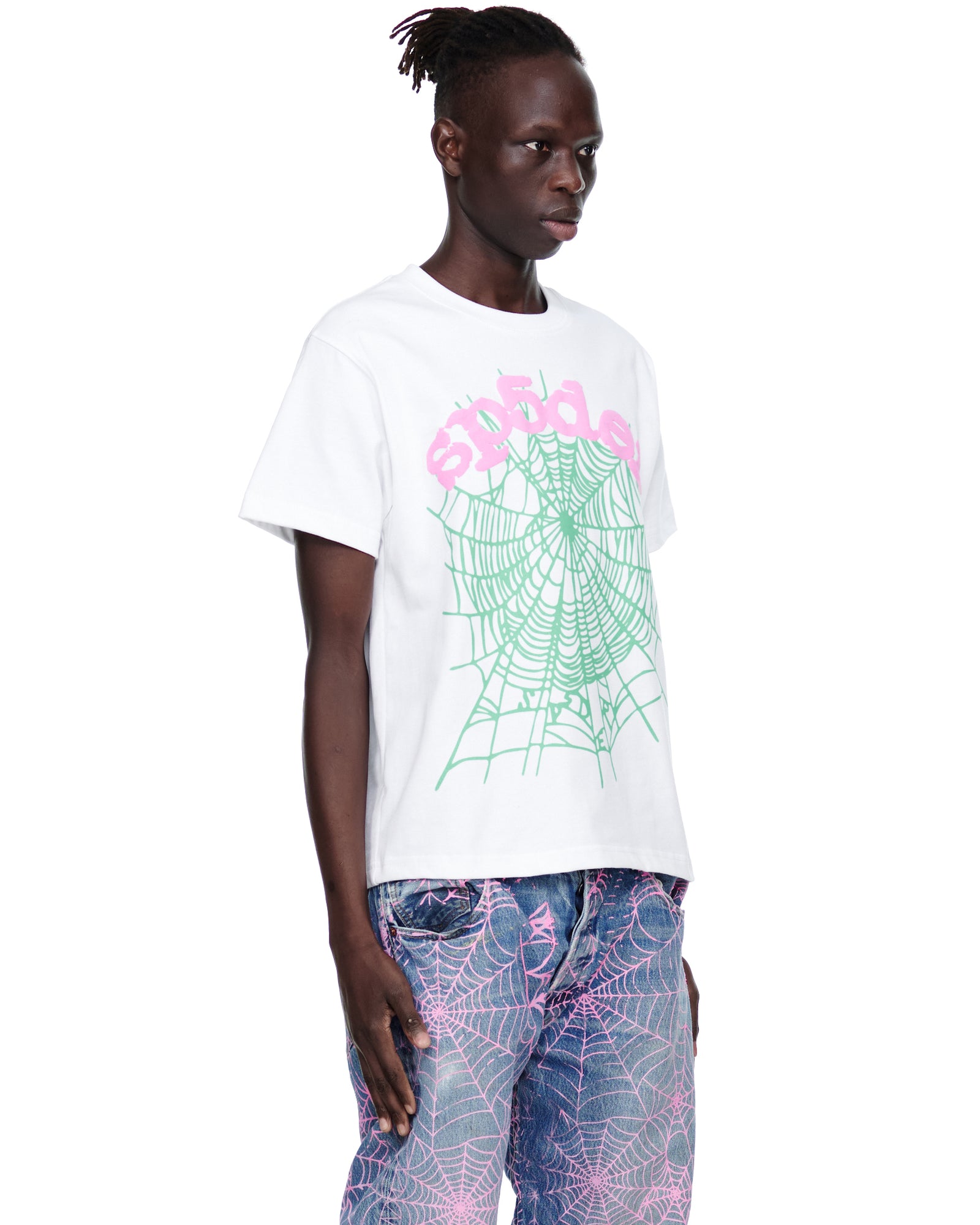 Male model in a white cotton OG WEB CANDY TEE with pink text and a green spider web print.