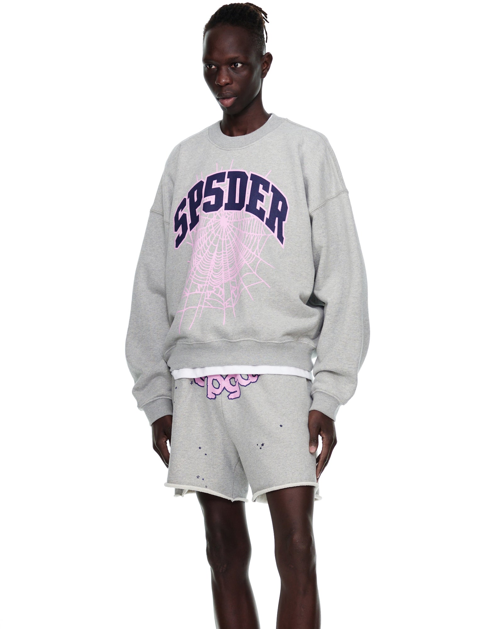 Grey VARSITY WEB CREWNECK with purple "SP5DER" and pink web print, worn by a model.
