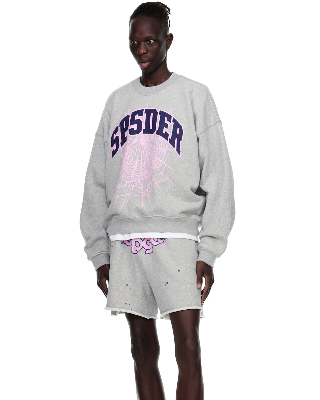 Grey VARSITY WEB CREWNECK with purple "SP5DER" and pink web print, worn by a model.