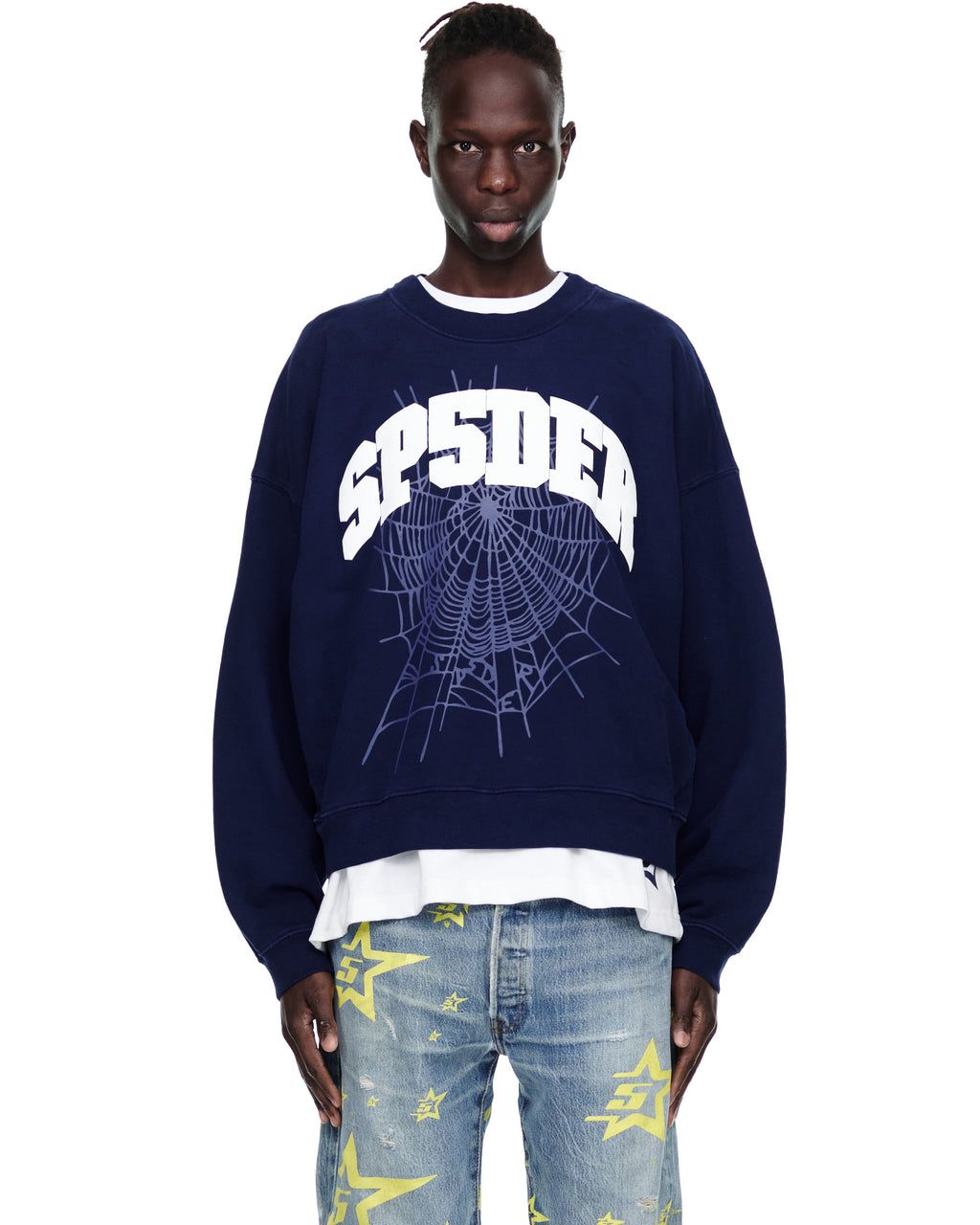 Male model in a navy VARSITY WEB CREWNECK with a white "SP5DER" graphic and spiderweb print.