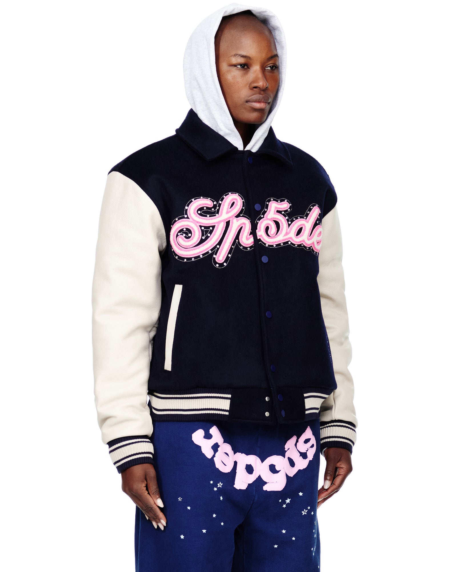 Navy wool varsity jacket with cream cowhide sleeves, pink chenille "Sp5der" patch, and striped knit trim.