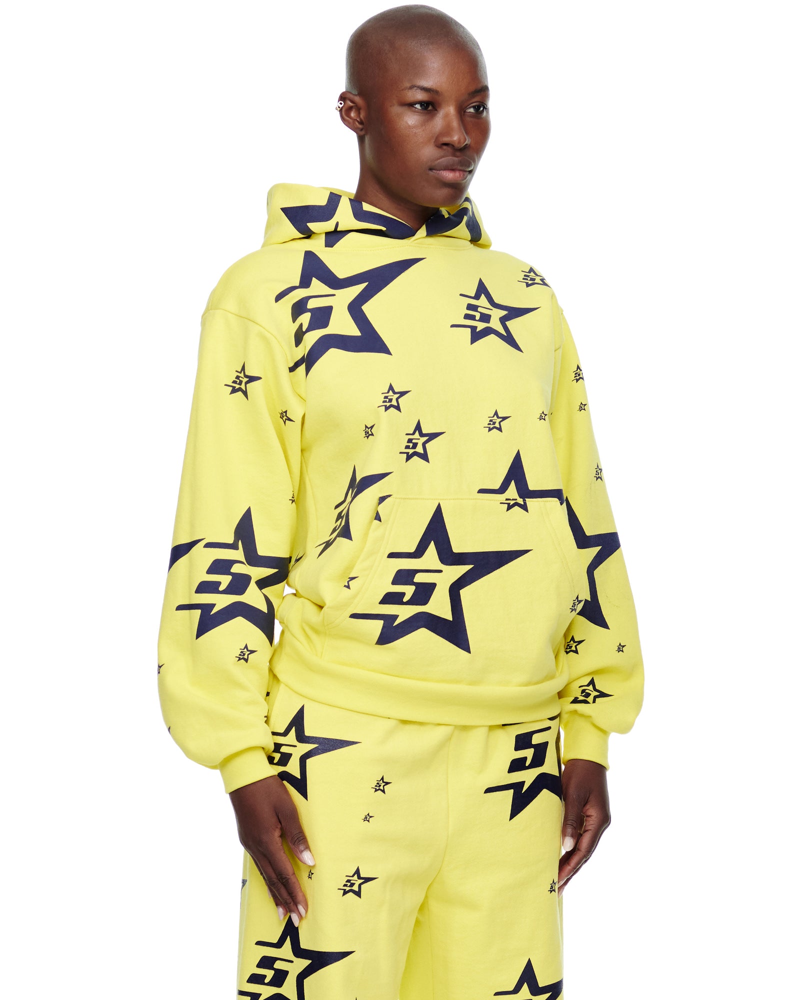 Yellow 5STAR HOODIE and sweatpants with all-over navy star print, worn by a model.