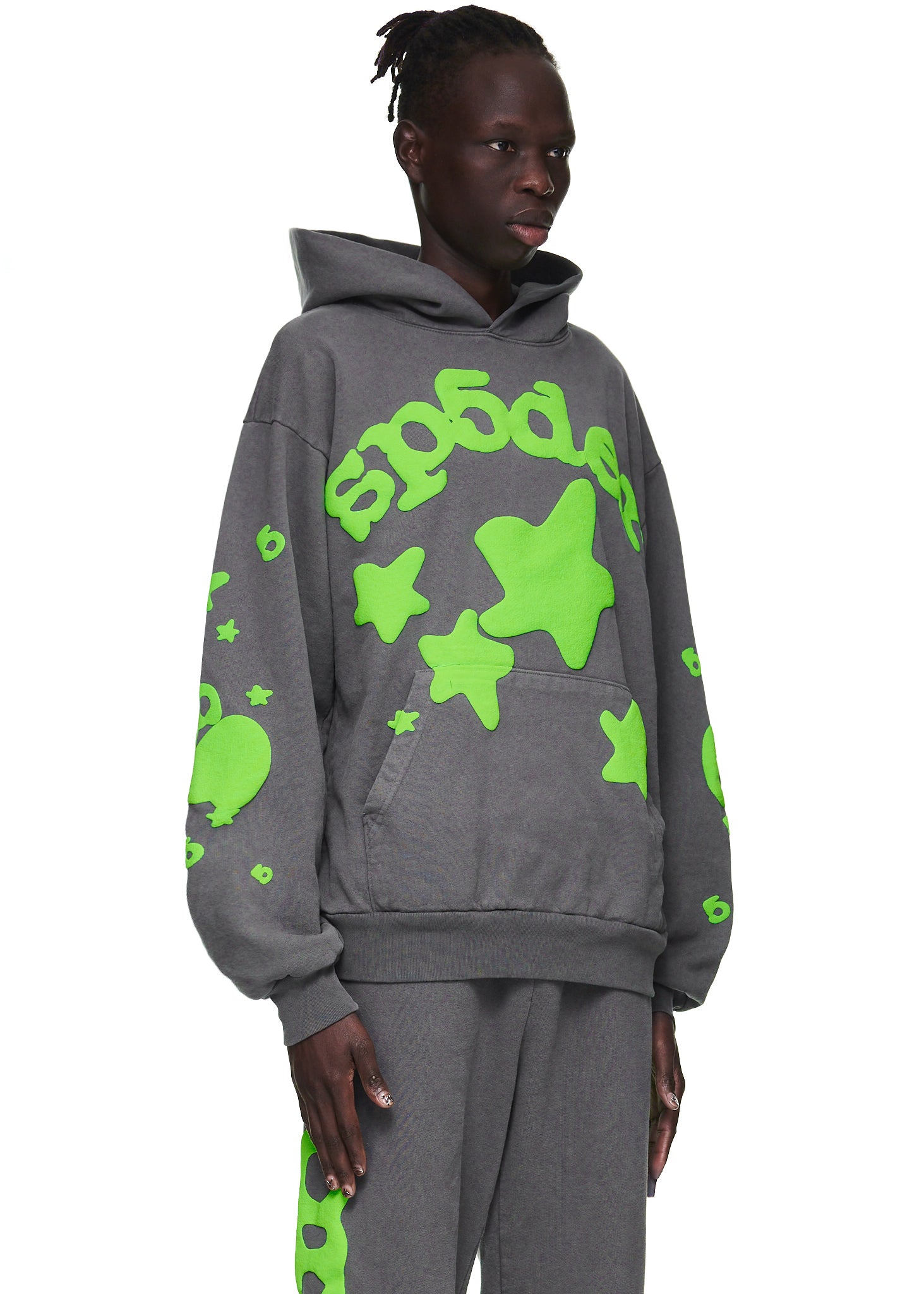 Male model in a slate grey Beluga hoodie with neon green "SP5DER" and star puff print.