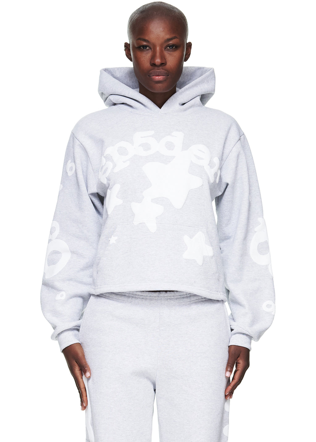 Women's cropped grey fleece hoodie with "SP5DER" and star puff print, paired with matching sweatpants.