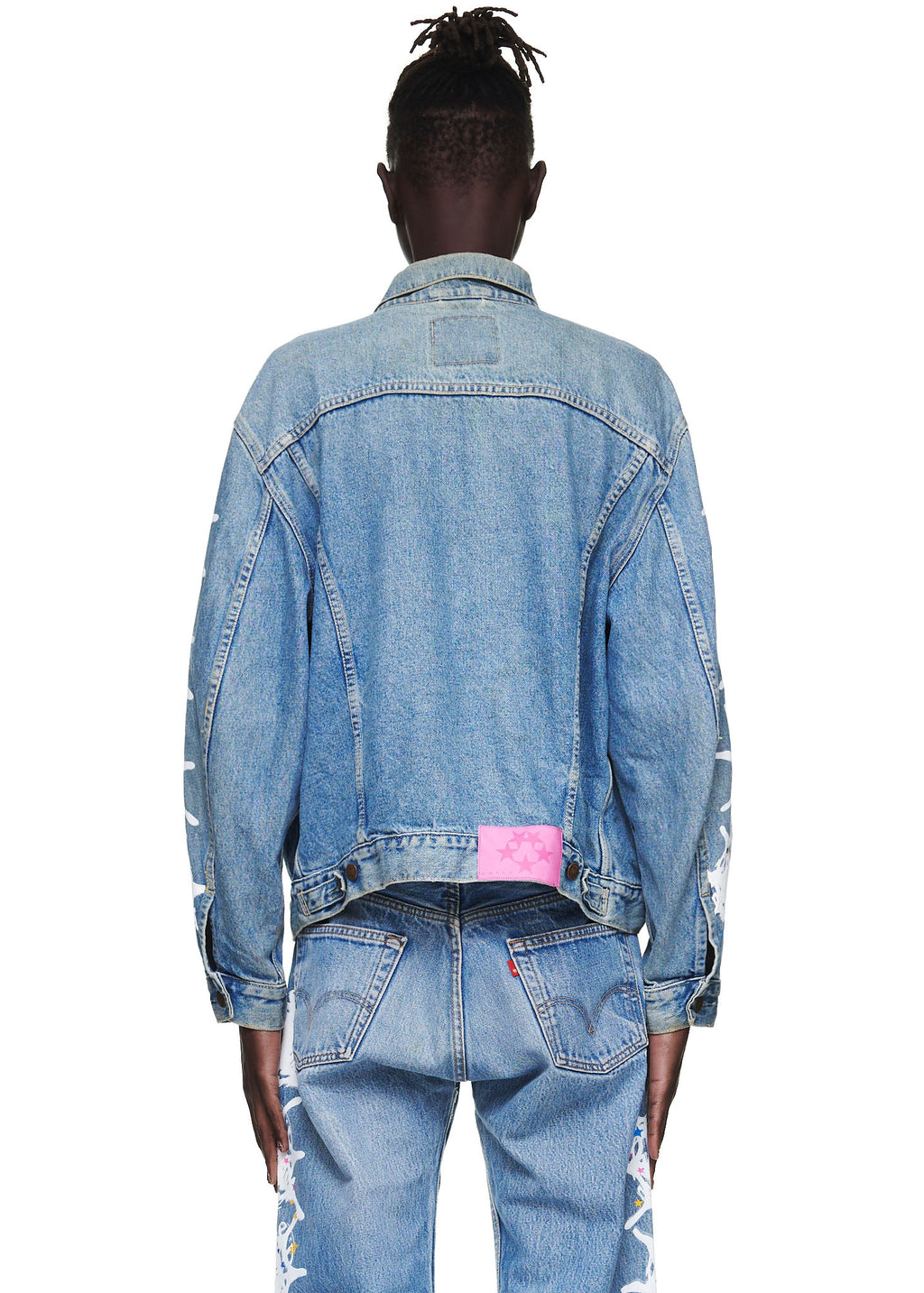 Vintage Levi's denim trucker jacket with a pink SP5DER leather back tab and white contrast web on arms.