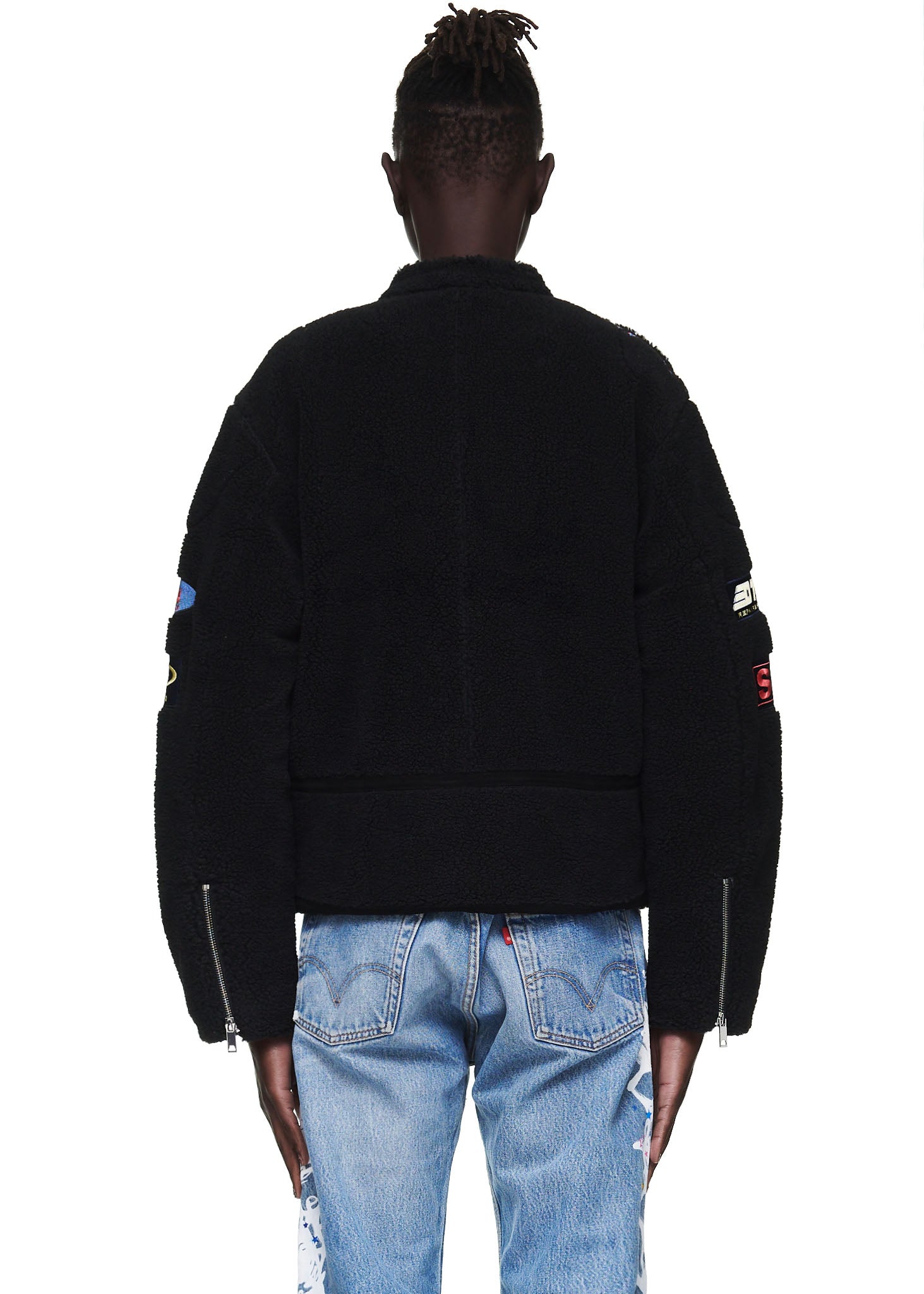 Black sherpa moto jacket with custom SP5DER patches, zip closure, and sleeve hem zippers.