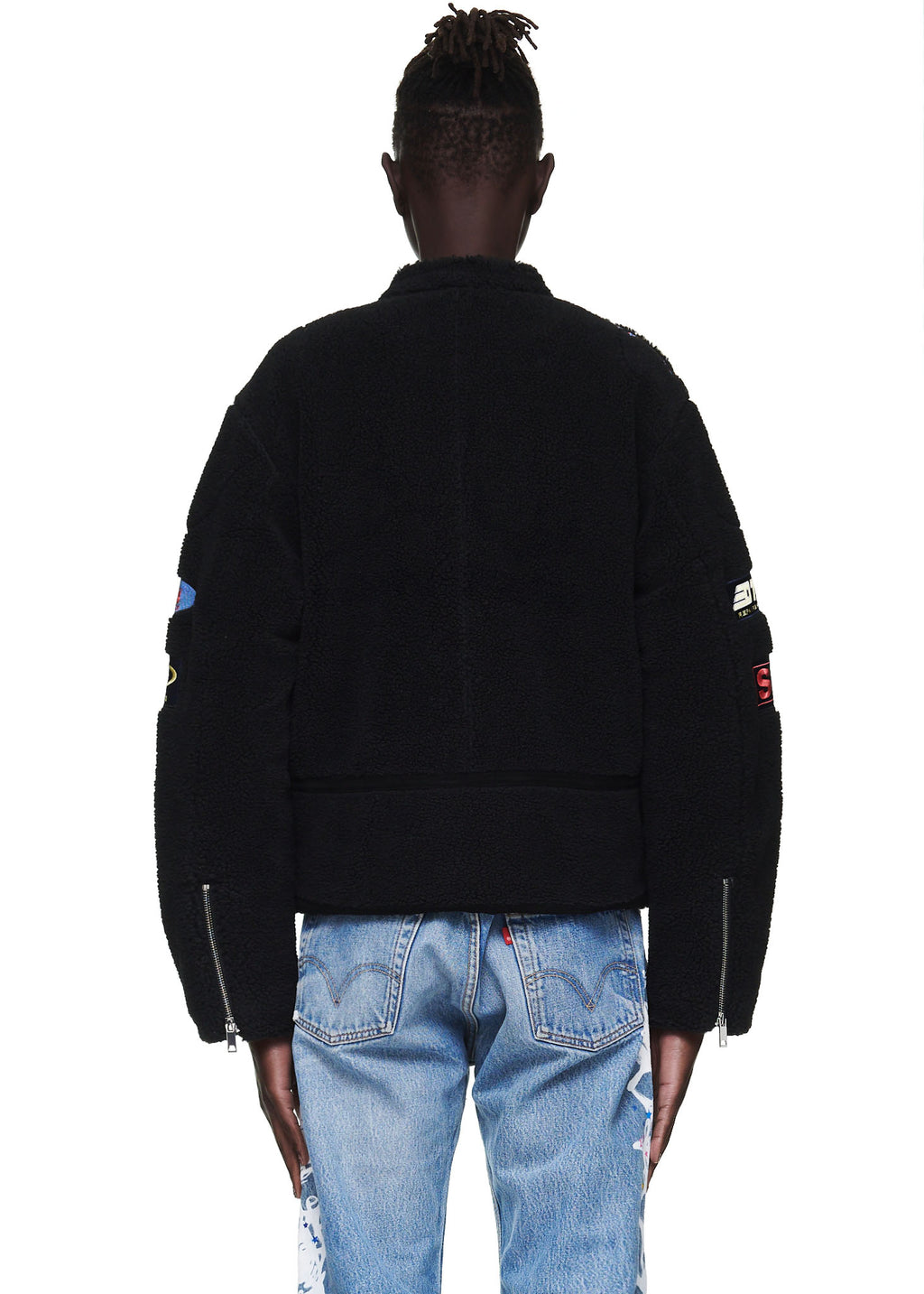 Black sherpa moto jacket with custom SP5DER patches, zip closure, and sleeve hem zippers.