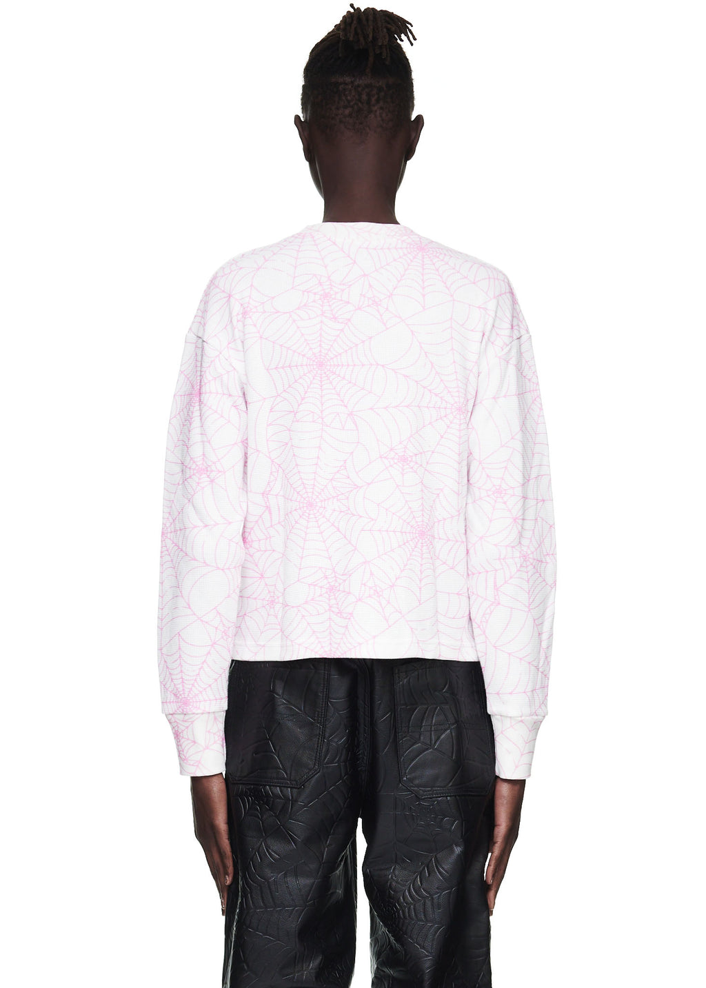 Back view of a male model wearing a white waffle thermal long sleeve shirt with an all-over pink spiderweb print.