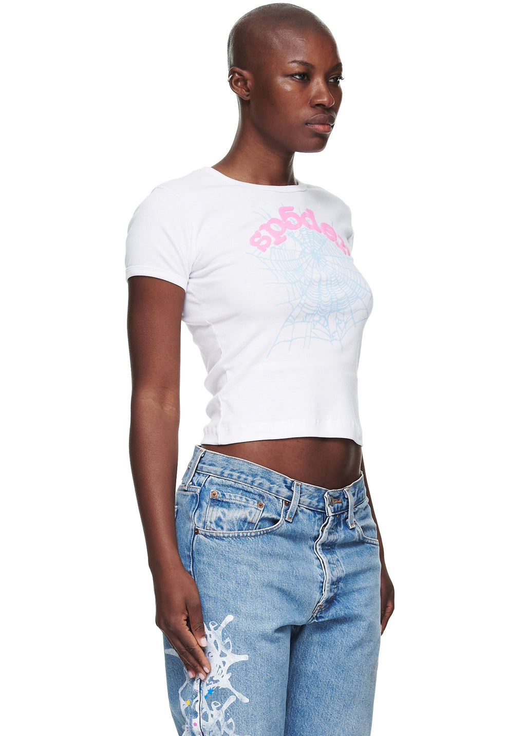 Female model in white cotton cropped tee with pink "sp5der" text and blue spiderweb graphic.