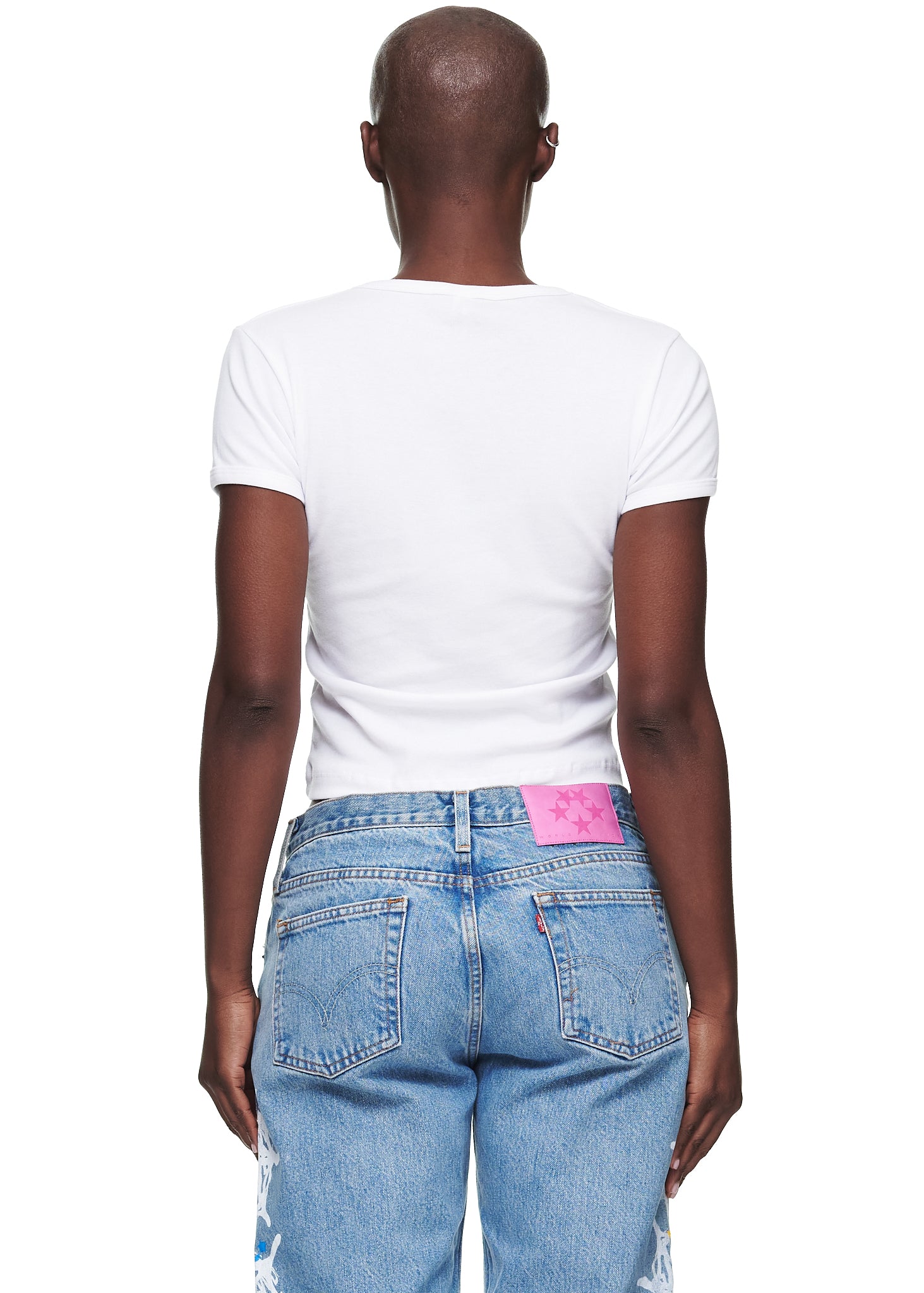 Back view of a female model wearing a white, cropped, fitted 100% cotton baby tee.