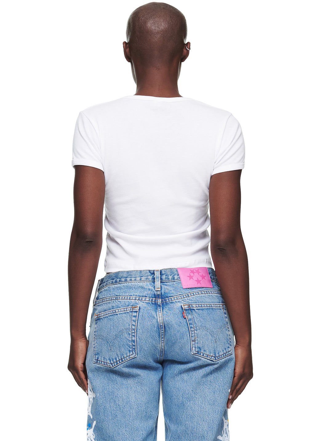 Back view of a female model wearing a white, cropped, fitted 100% cotton baby tee.