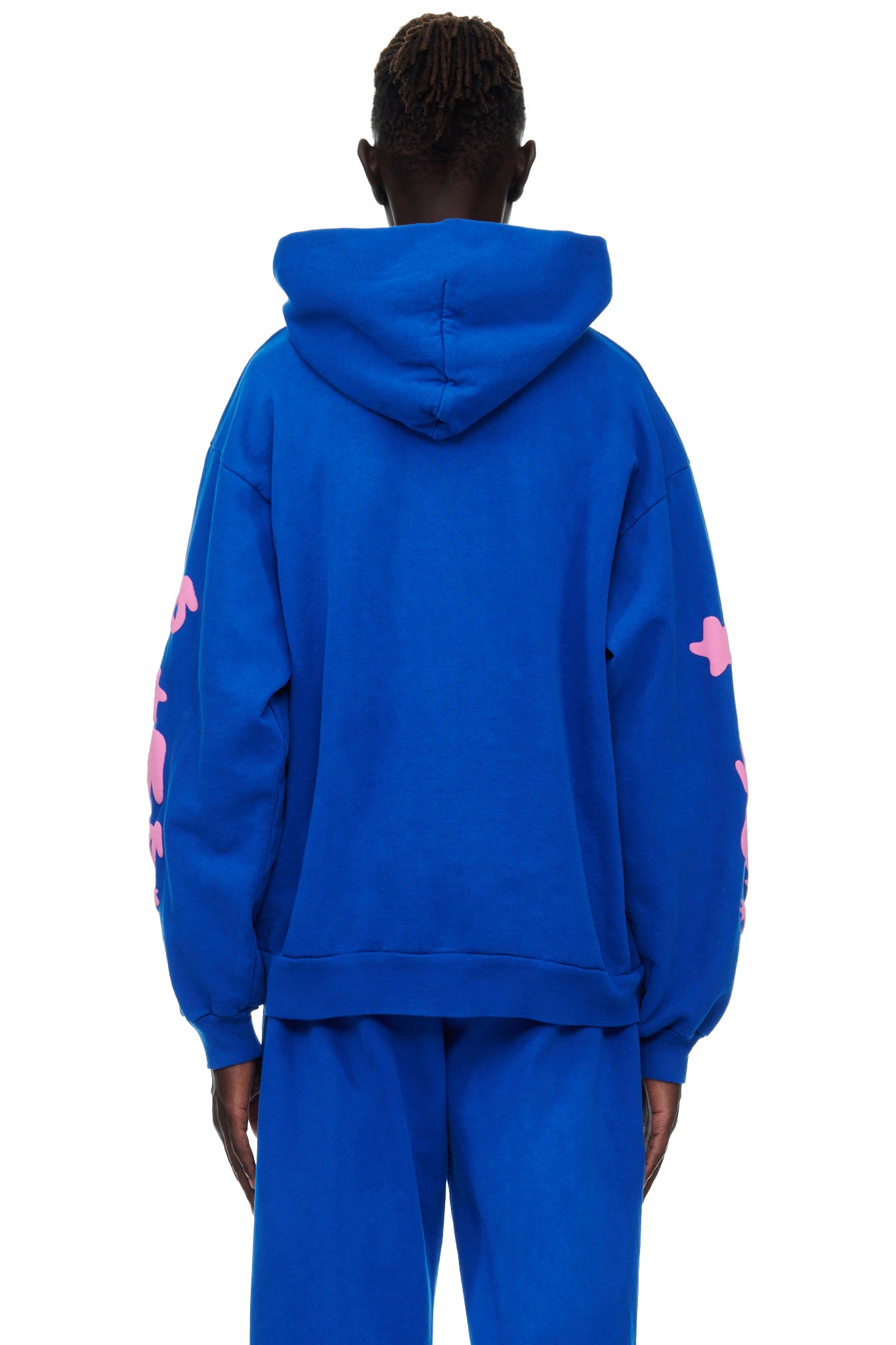 Back view of a male model wearing a blue 23oz fleece hoodie with pink puff print on the sleeves.