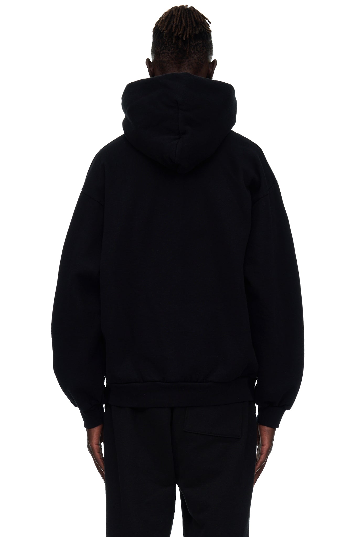 Back view of a black 23oz fleece hoodie worn by a male model, showing the hood and ribbed hem.