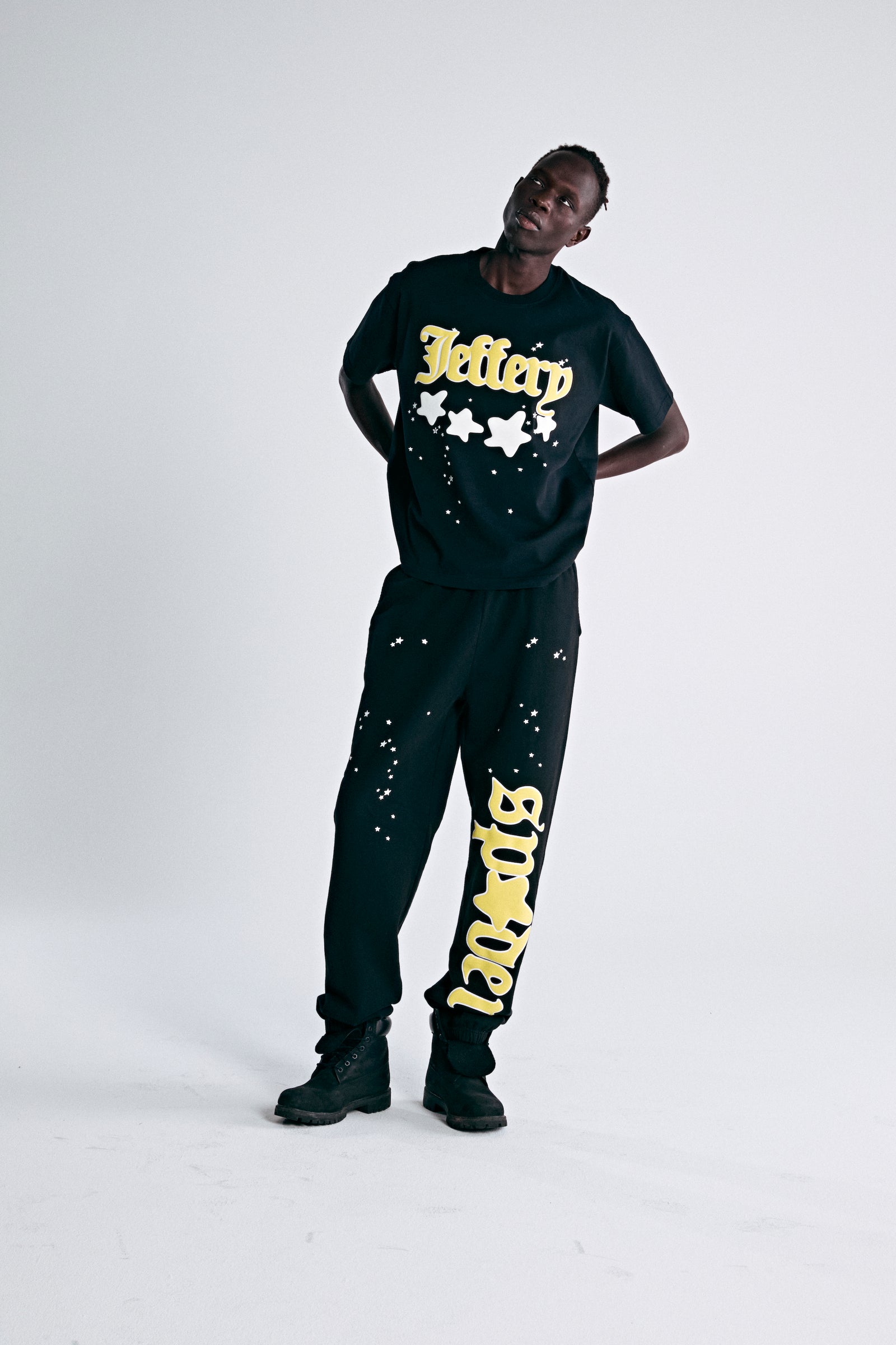 Black heavyweight cotton tee with yellow "Jeffery" puff print and discharge star graphics.