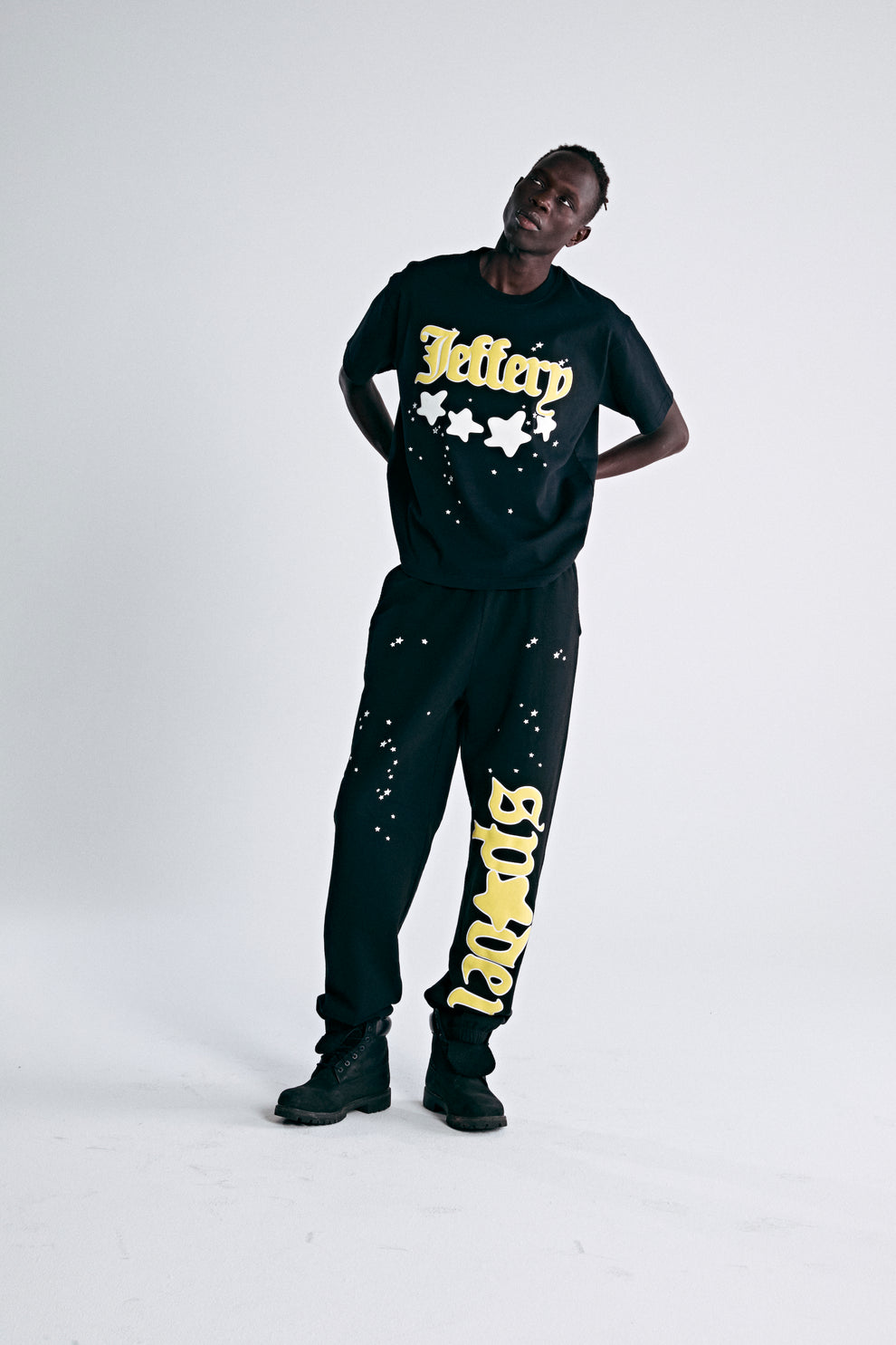 Black heavyweight cotton tee with yellow "Jeffery" puff print and discharge star graphics.